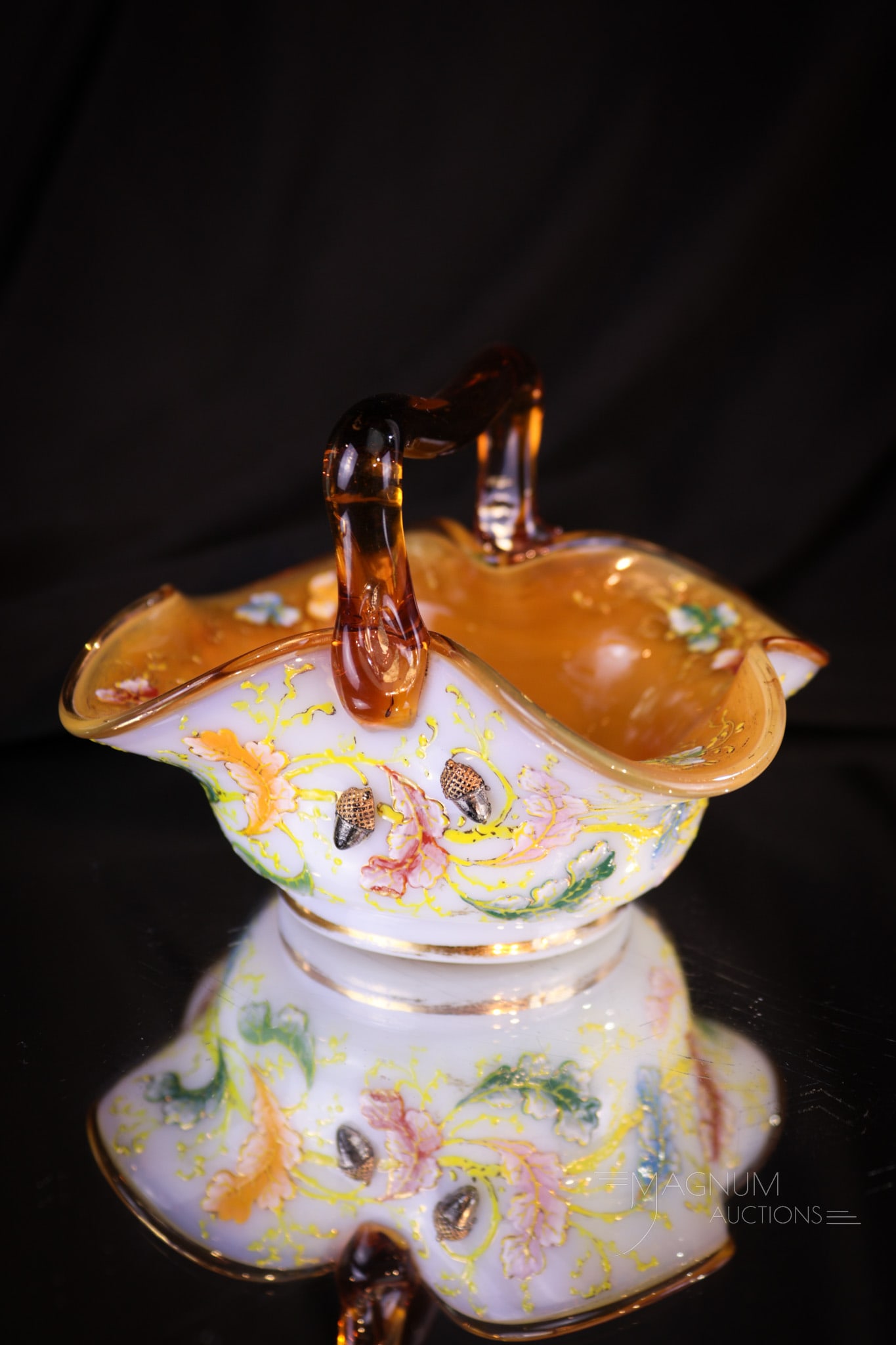 Signed Moser Acorn Enameled Cased Glass Victorian Basket: How charming this piece is! This Victorian art glass Moser basket is signed and has fine enameling and applied acorns around. Applied amber handle. Basket measures 3" tall, 4" wide.