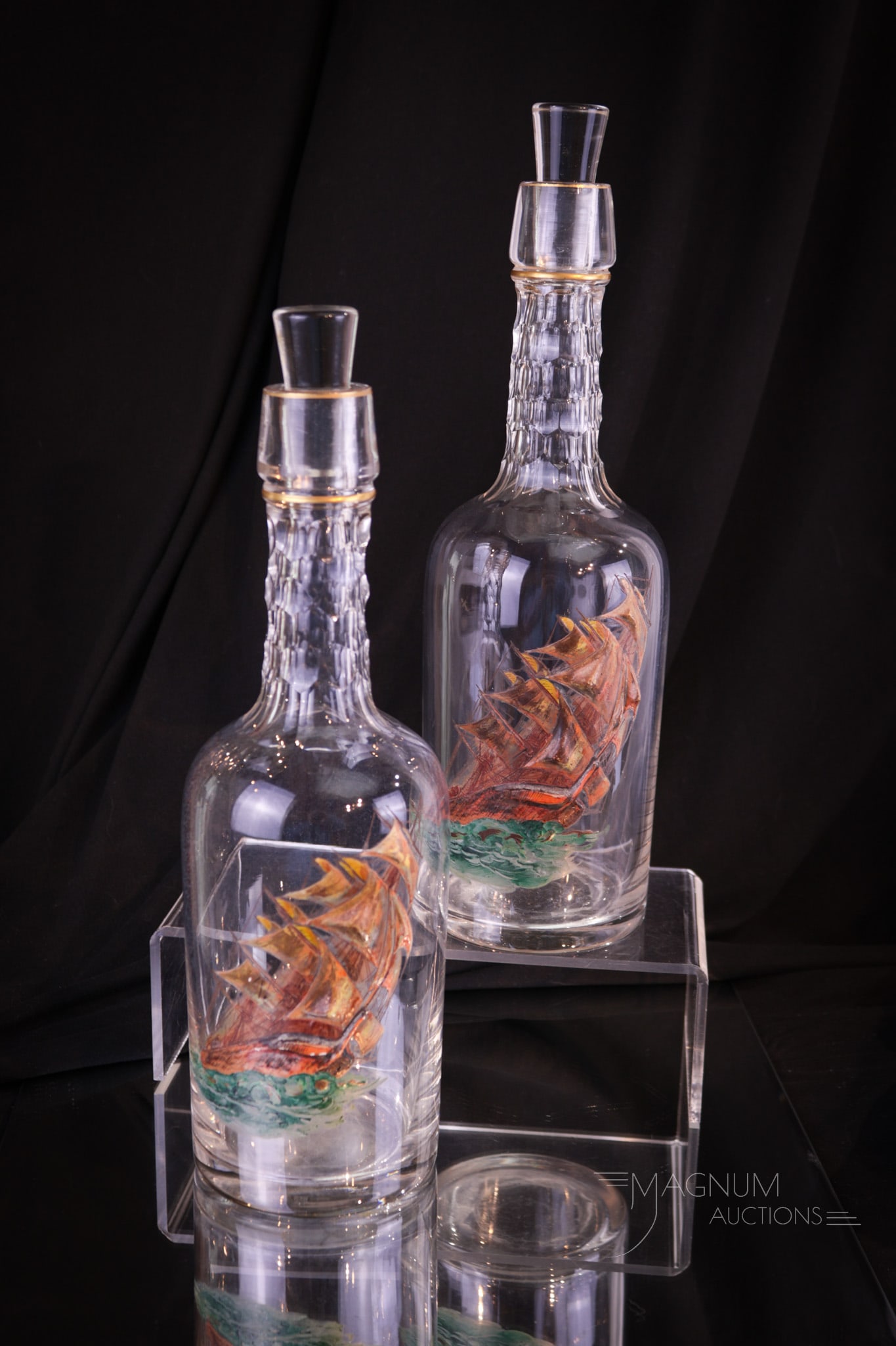 Moser Cut Heavy Enameled Glass Ship Decanter Bottles: A matched pair of attributed to Moser heavy built-up enameled decoration of sailing ships. Notch cut necks and gilt trim. Each bottle is complete with original matching stopper. Each measures 12" tall
