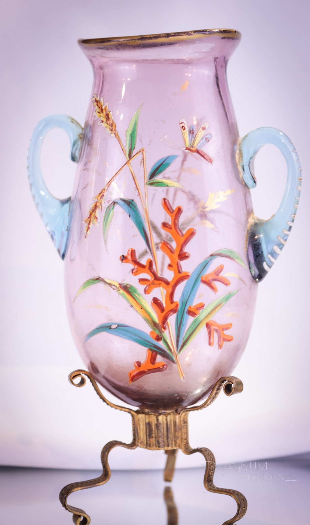 Moser Amber Enameled Glass Vase: A sweet little vase with applied blue handles and complete with ormulu base. Vase is decorated with flowers, leaves and dragonfly. A select piece in our Moser line-up. Vase measures 6 1/2" tall.