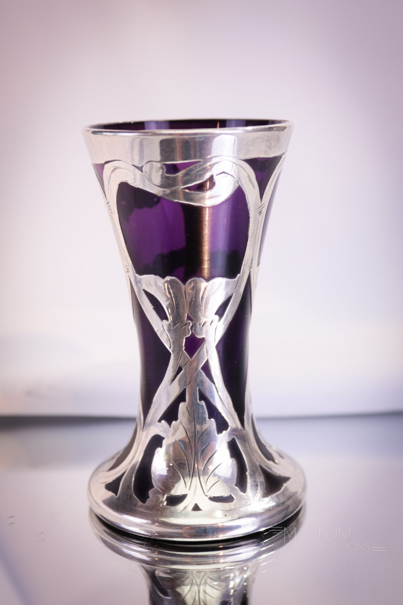 Amythest Art Glass Sterling Overlay Cabinet Vase: Diminutive in size, but big in impression. This little cutie is a collection-enhancing piece. Fine silver overlay on amythest colored glass in a sweet size. Vase measures 4" tall.