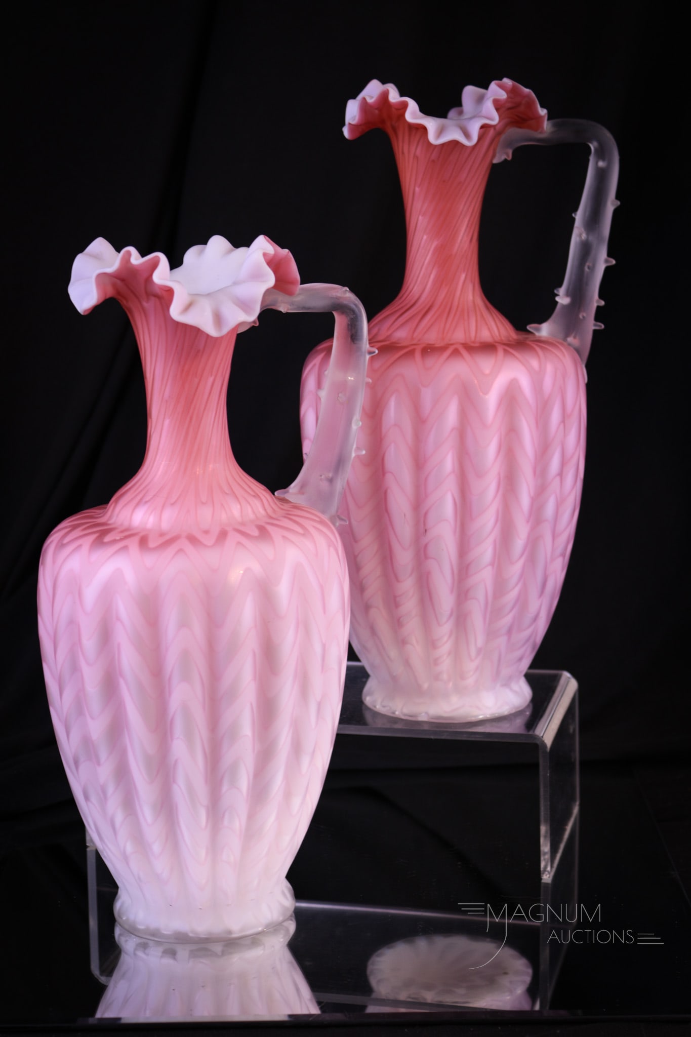 Pair 11" Victorian Herringbone Mother of Pearl Satin Glass Ewers: Well matched pair of 11" tall Victorian Mother of Pearl satin glass ribbed for pleasure ewers. Each with applied thorn handle. These are in the herringbone pattern. Each in a salmon orange-pink colori