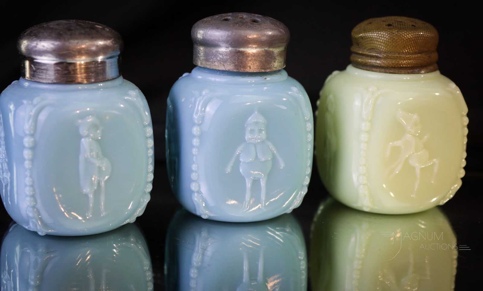 3 pc Lot Palmer Cox Brownie Opaque Glass Victorian Shakers: Three selections in opaque glass Victorian glass salt shakers with embossed Palmer Cox Brownies on them. Each measures 2 1/4" tall. Two examples in blue, and one in green.