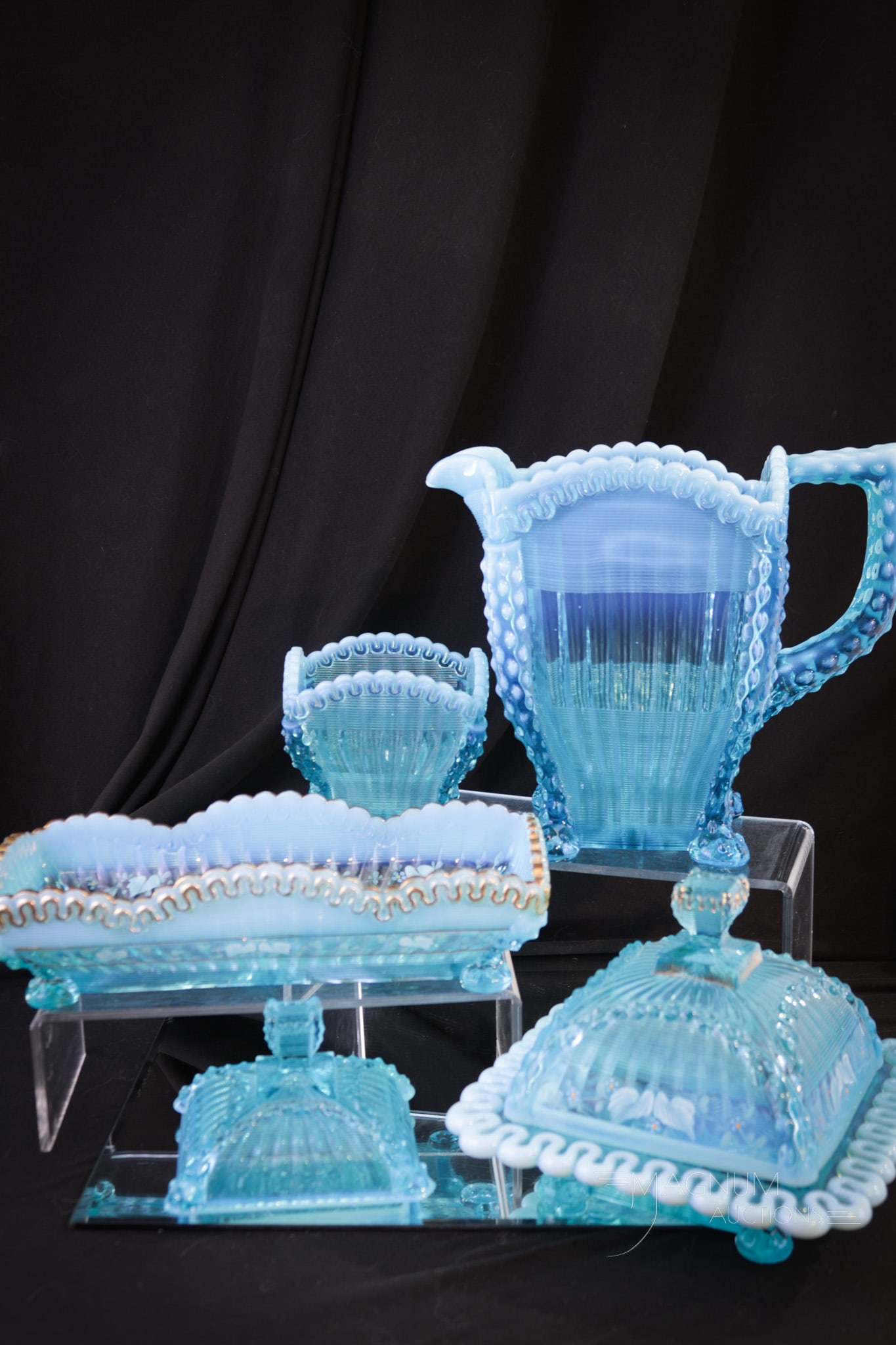 5 pc Lot Northwood Blue Opalescent Alaska Victorian Glass: Five selections sure to please in this lot of Northwood blue opalescent Alaska pattern. The butter and the celery are decorated. The water pitcher, spooner, and sugar lid are not. Tallest measures 7 1