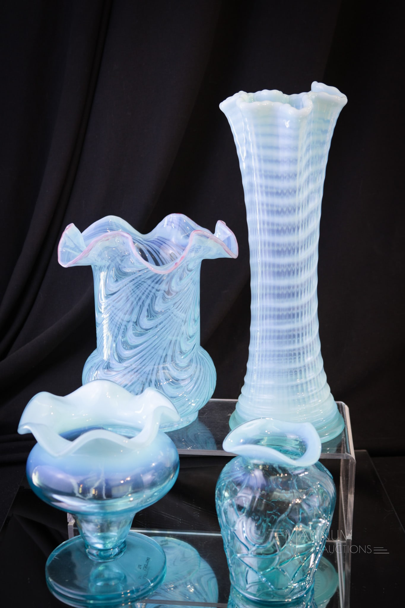 4 pc Lot Blue Opalescent Victorian Glass: Four select items in Victorian blue opalescent glass make up this lot. Included in the offering is a Ribbed Spiral swung vase, a Blown Twist celery vase, a Dugan Estate vase, and finished with a Tut v