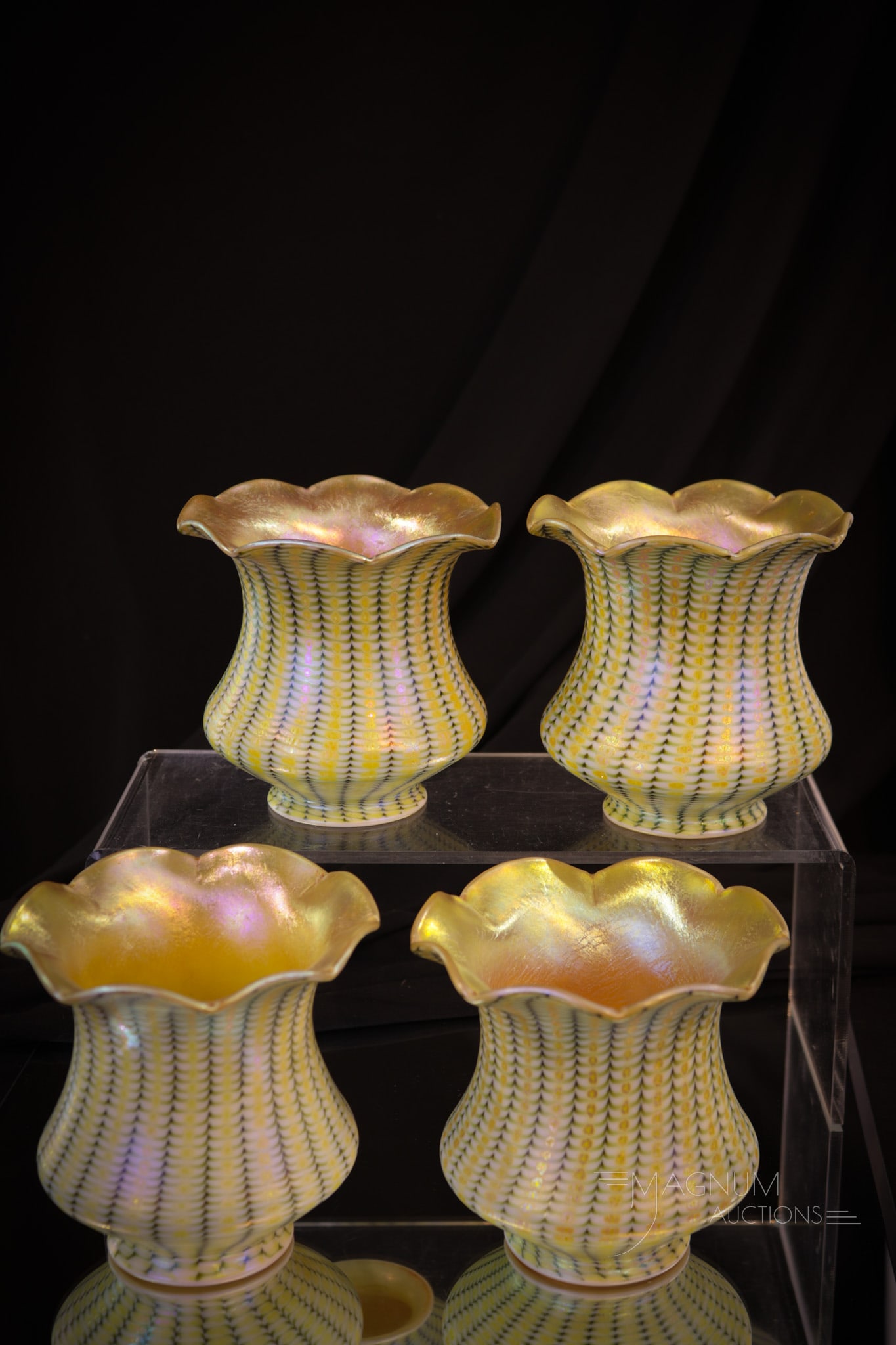 Set of Four Quezal Fostoria Zipper Art Glass Shades: Select offering of four unmarked Quezal or Fostoria art glass shades in the zipper pattern. Each is matched and features an orange interior. Shades measures 4 1/4" tall, 4 1/4" wide, and a 2 3/8" fitt
