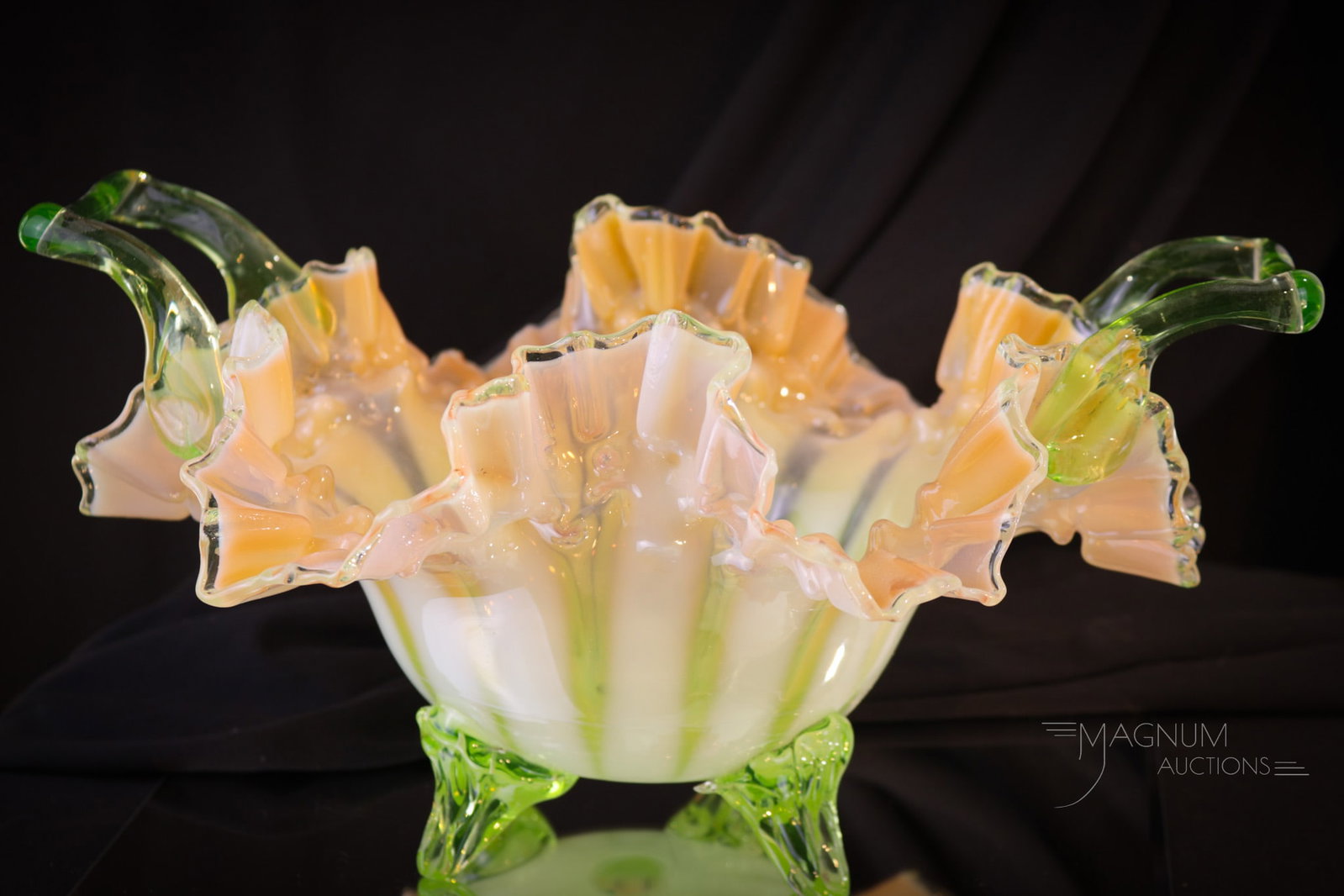 Large Rare Vaseline Peach Opalescent Stripe Glass Bowl: A large and rare find in vaseline glass. This bowl is peach color shaded vaseline glass with opalescent stripes and applied glass handles and feet. Bowl measures 7" tall, 14" wide. Chips to feet are n