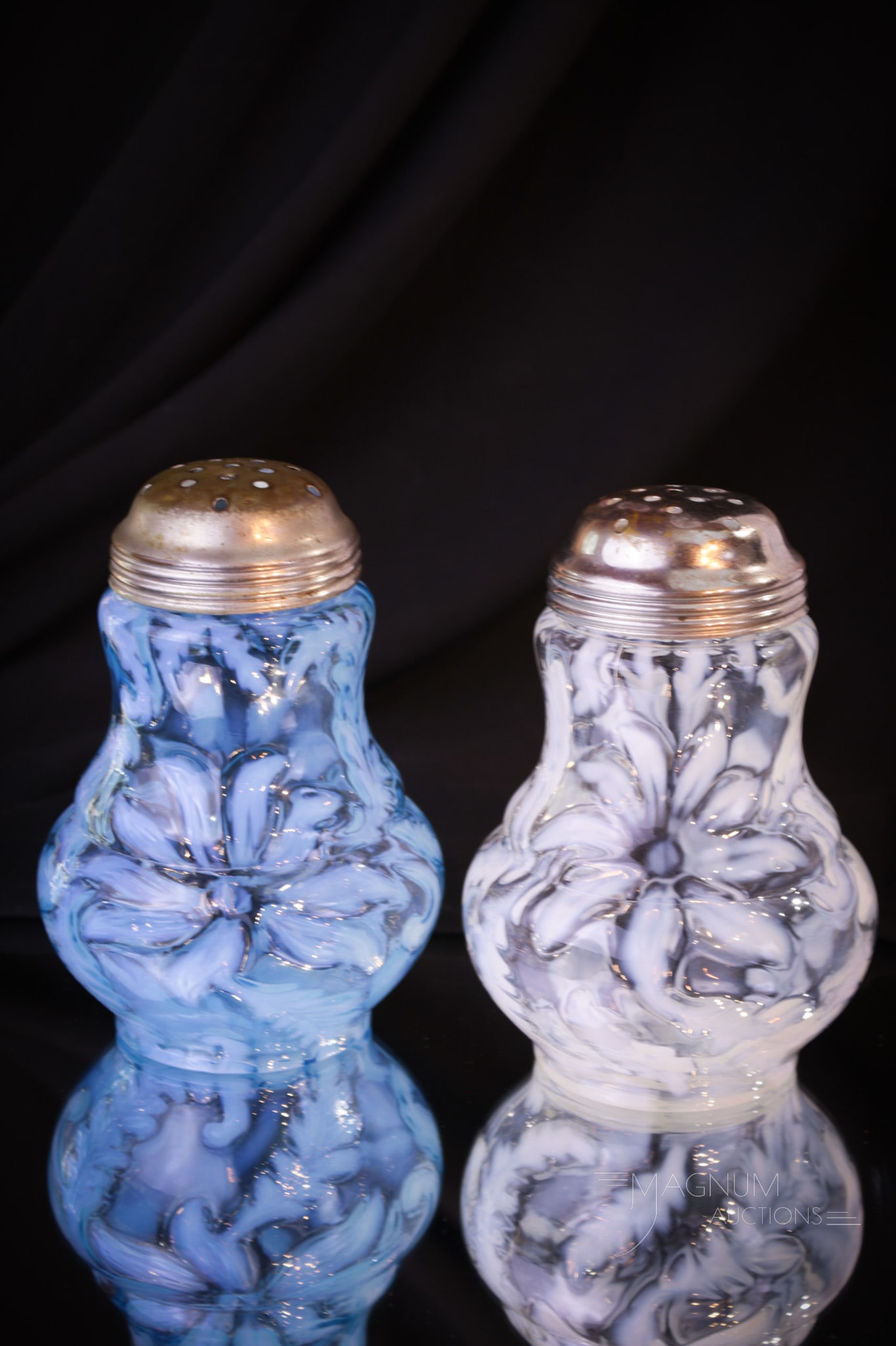 2 pc Lot Northwood Poinsettia Victorian Glass Sugar Shakers: Two wonderful examples of the popular Poinsettia pattern in sugar shakers. One in crystal opal and one in blue. Each measures 5" tall.