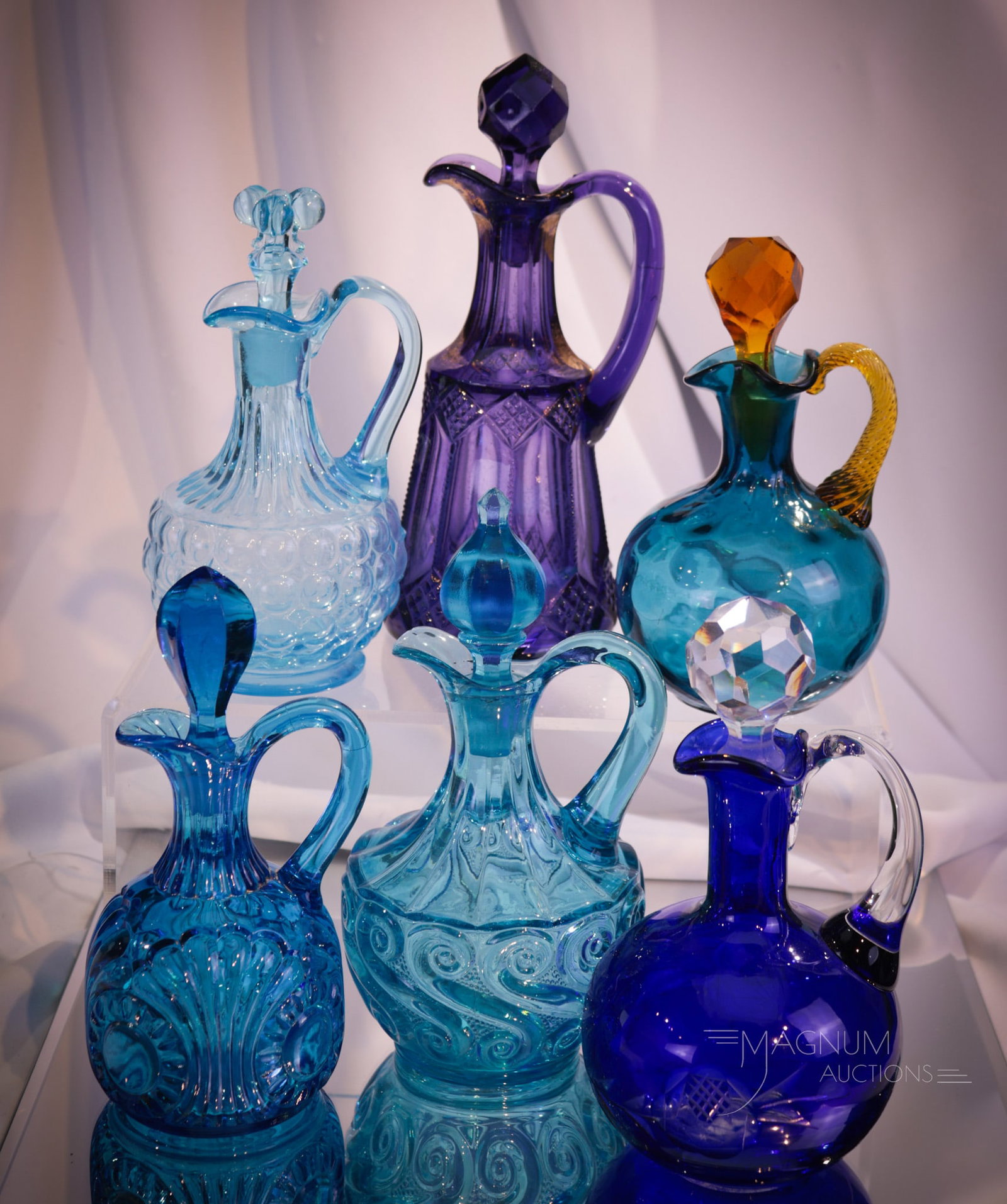 6 pc Lot Victorian Blue & More Pattern Glass Cruets: A half dozen cruets for your bidding pleasure. Five are blue. One is in altered-purple by radiation. Makers such as Adams, Jefferson, and more. Tallest measures 8".