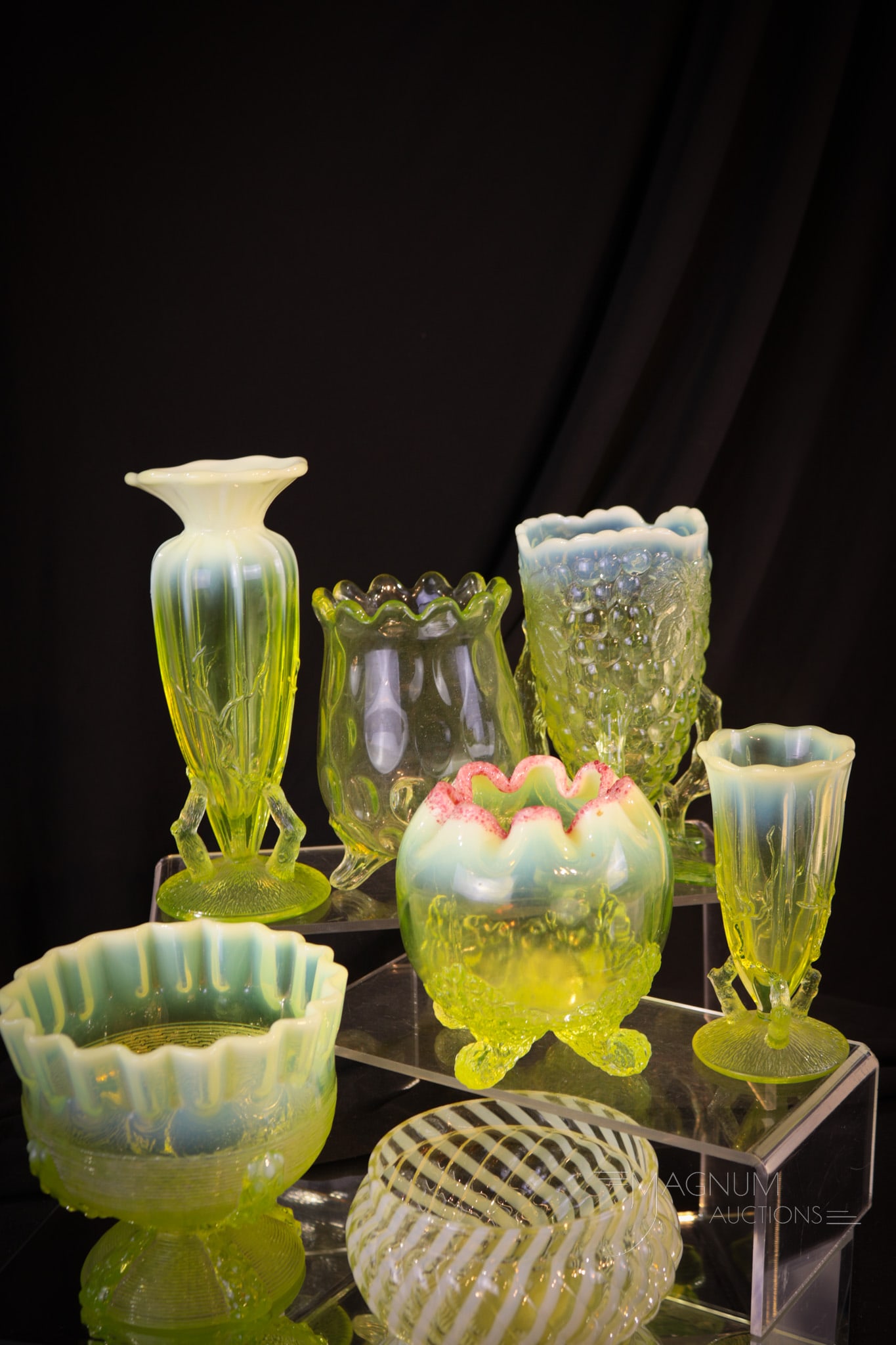 7 pc Lot of Amazement in Victorian Vaseline Glass: Seven finds to talk to your Vasie friends about. This lot includes two rose bowls, a berry bowl, two twig vases, a spooner, and a grape cluster vase. Tallest measures 7".