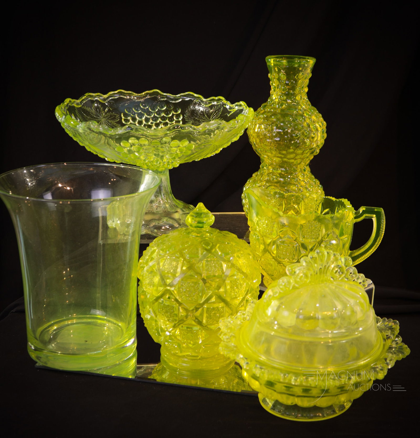 6 pc Lot Vaseline Glass Goodies: A half-dozen finds in vaseline glass for your bidding pleasure. This lot includes a Grapes compote, a Quilt creamer and sugar, a Doric butter and more. Tallest measures 7".