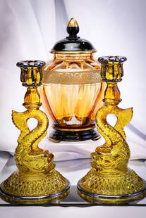 3 pc Lot Cambridge Glass Candlesticks & Temple Jar: Three fine examples of Cambridge glass in this three-piece lot. A pair of candlesticks with silver trim and a temple jar with nice gold band complete with the ebony base. Tallest measures 9 1/2".