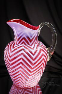 Northwood Cranberry Opalescent Ribbed Herringbone Victorian Water Pitcher: A show-stopping example of Northwood's cranberry Ribbed Herringbone Victorian water pitcher. This pitcher has deep rich cranberry color and bright white opal. Go find one! Pitcher measures 9" tall.
