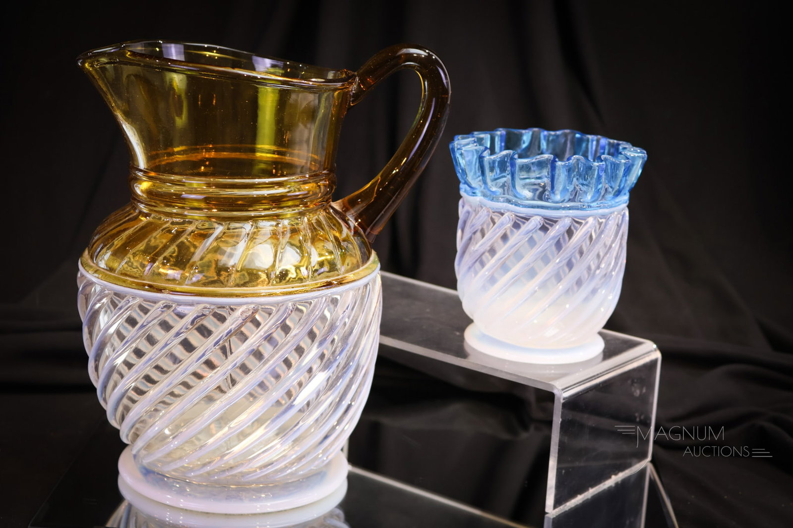2 pc Lot Victorian Opalescent Gonterman Swirl Water Pitcher & More: Two select examples of Victorian glass opalescent Gonterman Swirl pieces. We have an amber opal water pitcher and a blue opal spooner. Each example features nice coloring and opal. Tallest of the lot 