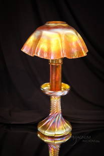 Tiffany Studios 12" Gold Favrile Candle Lamp: A fine Tiffany gold Favrile candle lamp. This lovely lamp is complete with the original shade and gold Favrile glass candle. Base is signed, "L.C.T., Favrile. Lamp measures 12" tall.