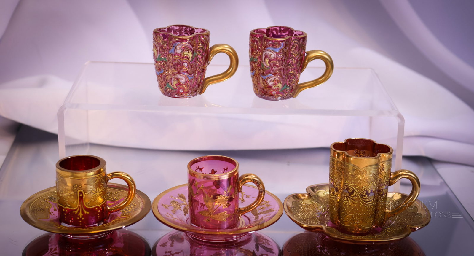 8 pc Lot Moser Miniature Cranberry Decorated Cups & Saucers: Eight fine pieces of cranberry Moser miniature cups and saucers. Each is decorated. The tallest measures 1 7/8".