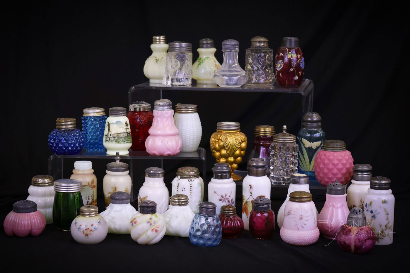 39 pc Lot Victorian Glass Salt Shakers: Thirty-nine delights in Victorian glass salt shakers that are sure to please. This lot includes Pink opaque, opal, cranberry enameled, blue, and more. The largest measures 4 1/4"" tall and 1 1/2"" wid