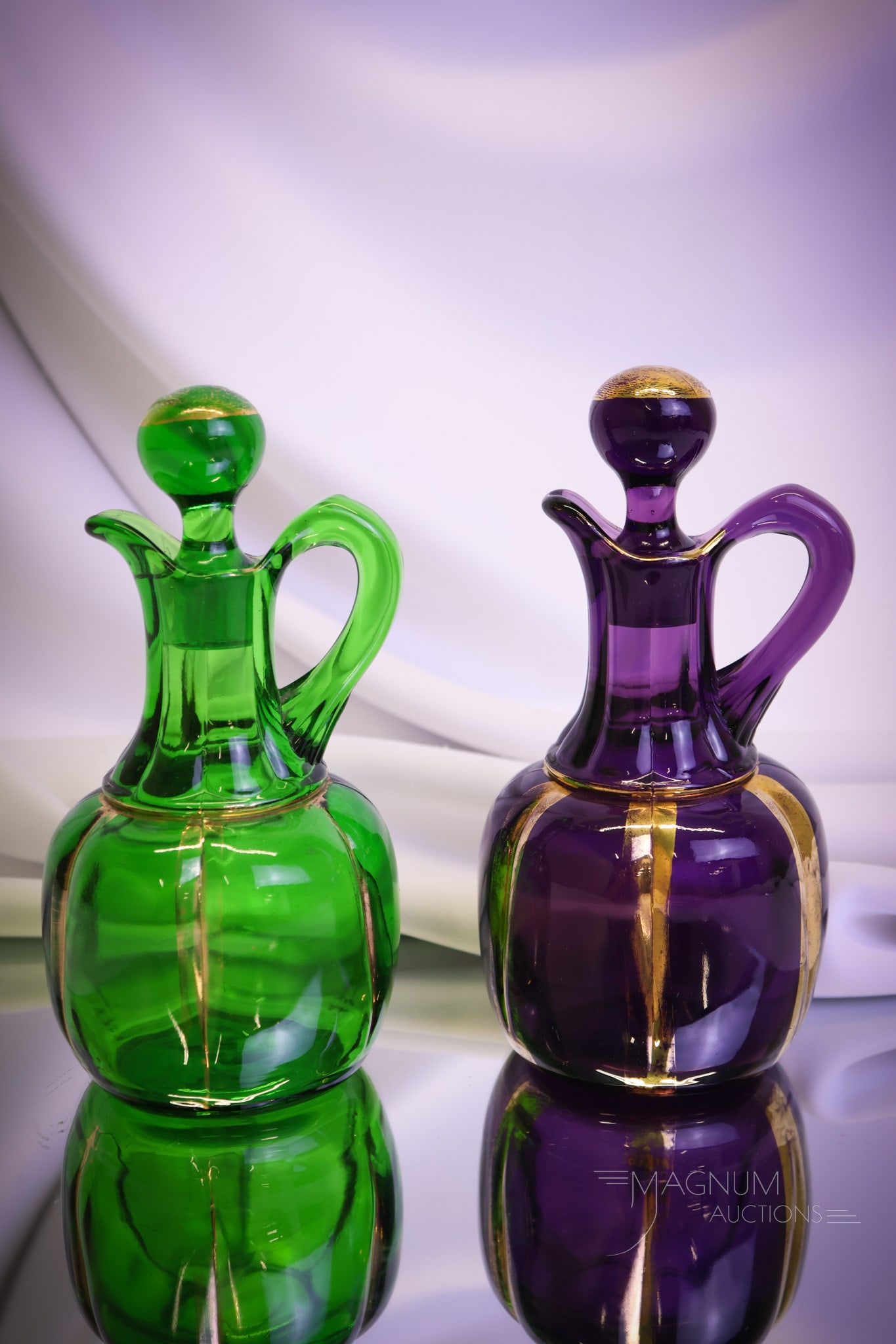 2 pc Lot Riverside Victorian Glass X-Ray Cruets: Two beautiful and desirable Riverside glass Victorian cruets. One in amethyst, and one in green. Both have gilt decoration. Each measures 6 1/2"" tall and 3 1/2"" wide. Shipping: At checkout, select