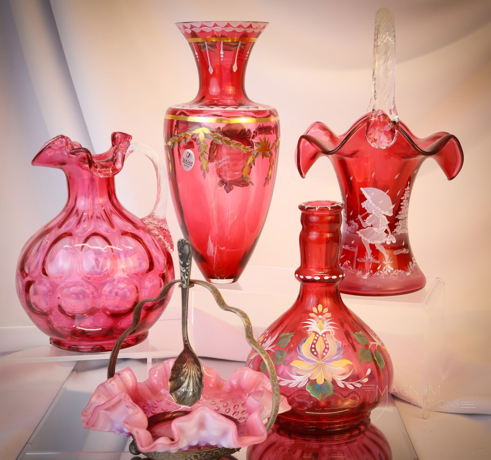 5 pc Lot Fenton Cranberry Glass: Five selections sure to please in this offering of Fenton cranberry glass. This lot includes a Mary Gregory style decorated basket. A hand-painted vase. A cranberry jug. A hand-painted Amphora vase, l
