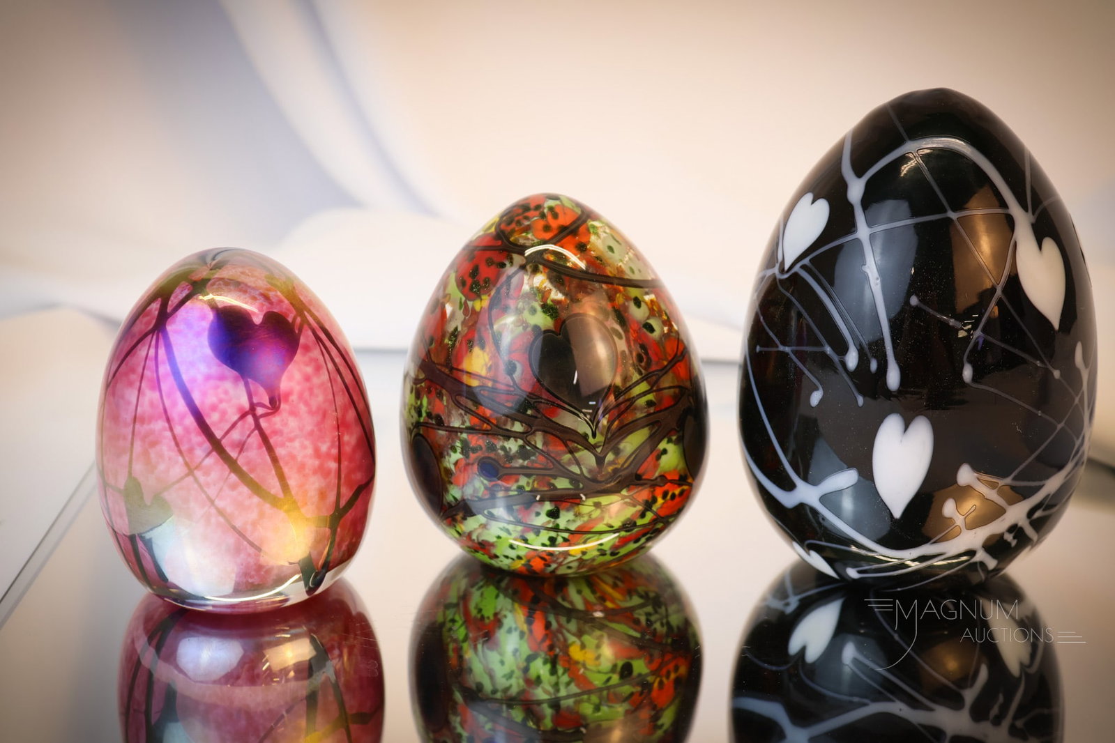 3 pc Lot Fenton Dave Fetty Art Glass & More Eggs: Three beautiful Fenton Dave Fetty and more art glass eggs. The first is unattributed and is in a pink mottled hanging heart decoration. The second and third are Fenton Dave Fetty examples. One is a ra