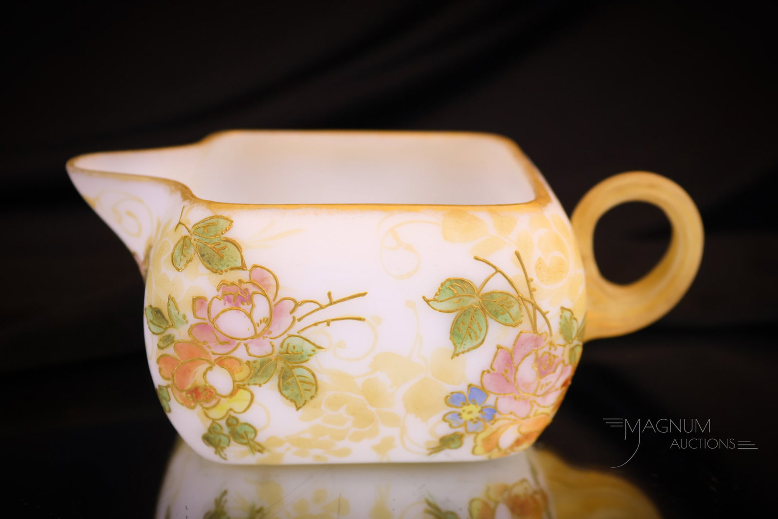 Mt. Washington Crown Milano Victorian Glass Floral Creamer: Another fine creamer in our Mt. Washington glass section of the auction. This creamer has floral decoration around the body and gilt highlights. The creamer measures 2" tall and 5" wide. Shipping: At 