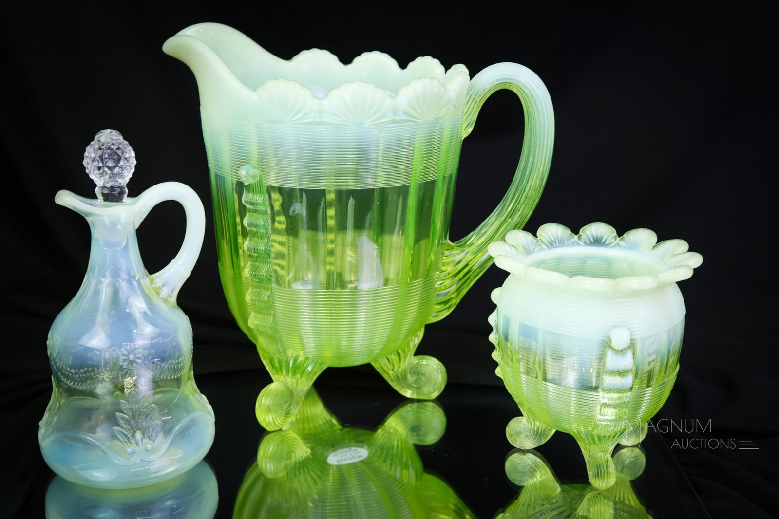 3 pc Lot Victorian Vaseline Uranium Opalescent Glass: Three fun finds in Victorian vaseline opalescent glass by Northwood and Jefferson. This lot includes a Fluted Scrolls pattern water pitcher and spooner, along with a Swag with brackets cruet. The tall