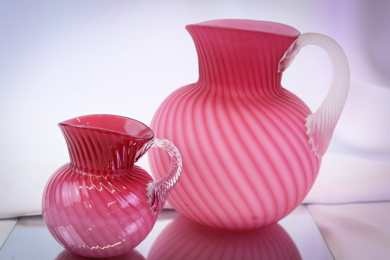 2 pc Lot Hobbs Victorian Glass Cased Glass Pitchers: Two delights to behold for your bidding pleasure. This lot offers a pitcher and a creamer in the Neapolitan pattern by Hobbs. The water pitcher is satin finished, and the creamer is glossy. The talles