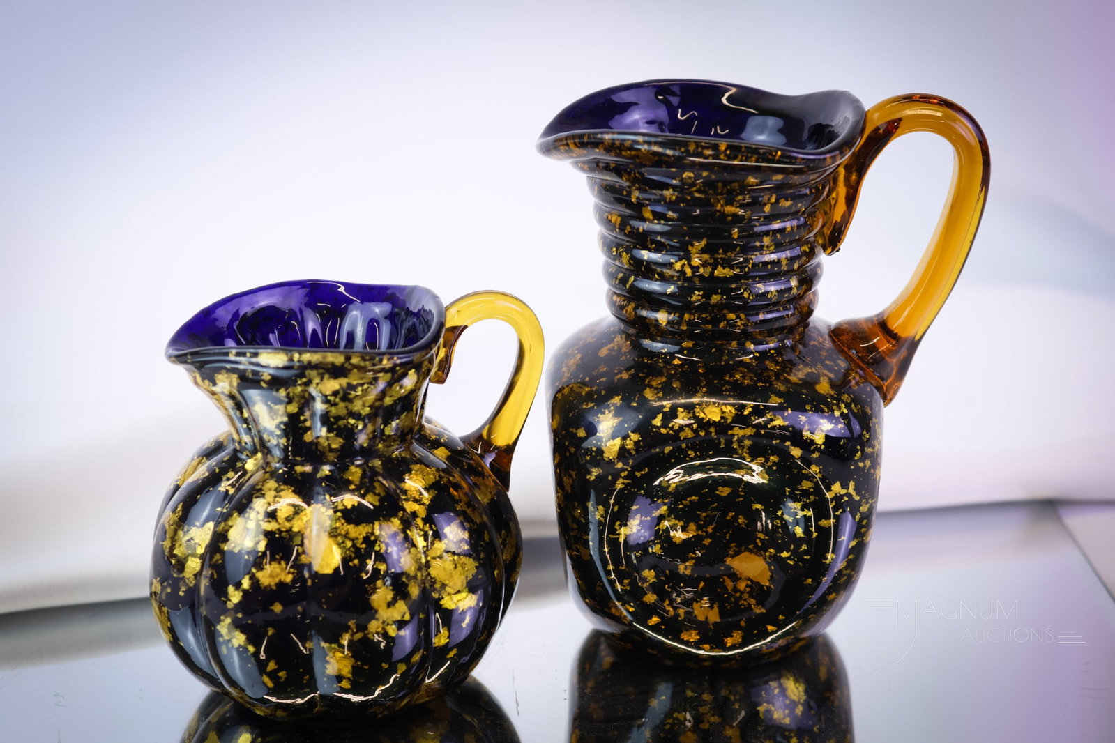 2 pc Lot Hobbs Victorian Spangle Glass: Another offering to delight the Hobbs collectors out there. This lot features two creamers in varying forms. In cobalt with gold spangle. The tallest measures 5". SHIPPING NOTICE: If you choose not to