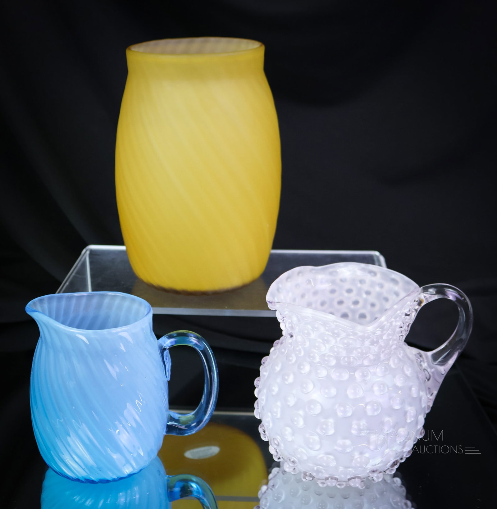 3 pc Lot Hobbs Victorian Cased Glass Satina Swirl & More: Three superlative examples of Hobbs Victorian cased glass. This lot includes a satin celery vase, a creamer, and a small childs pitcher in the Hobnail pattern. The tallest measures 6". SHIPPING NOTICE
