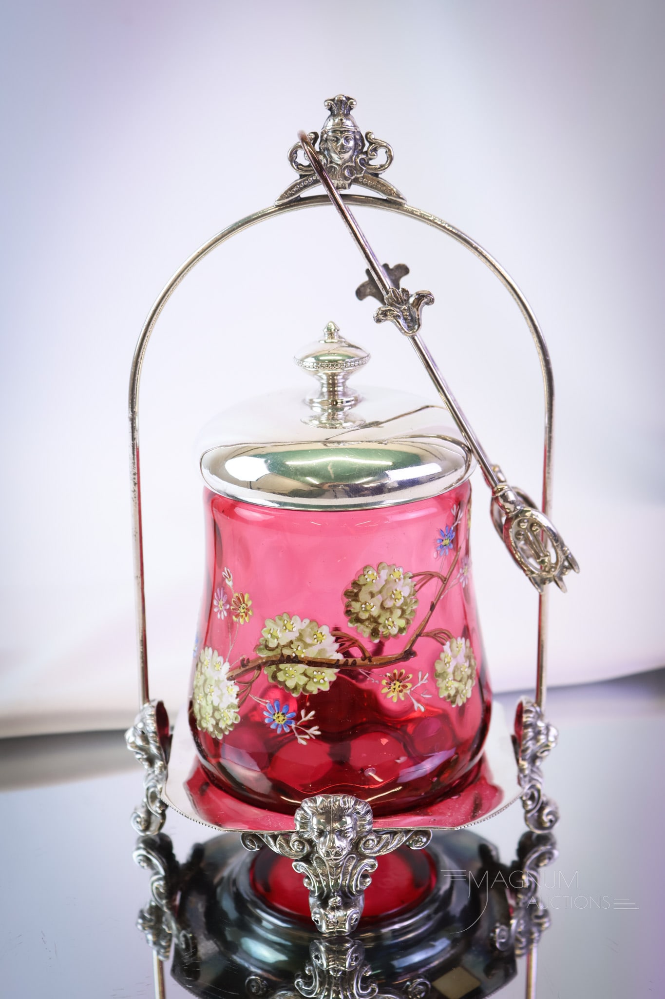 Victorian Cranberry Enameled Glass Silverplate Pickle Castor: A stunning and ornate Victorian silverplate and glass pickle castor. This divine piece is yet another showy example of the fineries presented by Magnum Auctions. This castor is complete with an ornate