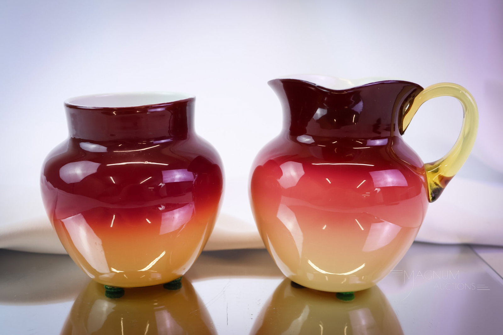 2 pc Lot Hobbs Wheeling Peachblow Victorian Glass: Two distinct examples of Victorian Hobbs Wheeling peachblow glass. This lot includes a creamer and a vase, each with super coloring. The tallest measures 4 1/4". SHIPPING NOTICE: If you choose not to 