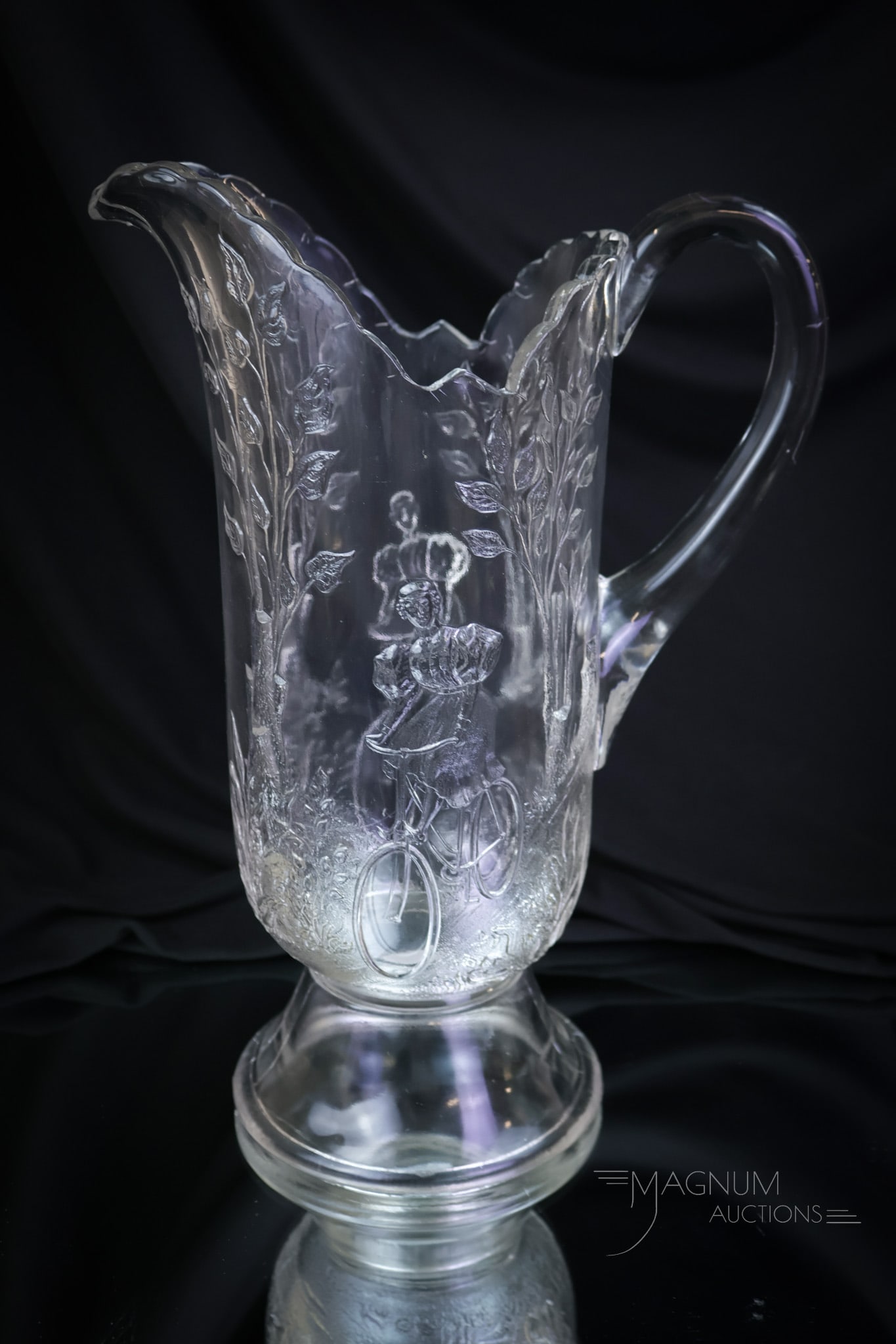 Greentown Glass Bicycle Girl Victorian Water Pitcher: A seldom-found piece recently attributed to Greentown glass. This is a Bicycle Girl Victorian pitcher. This piece is perfect and a wonderfully hard-to-find piece. The pitcher measures 11" tall. SHIPPI