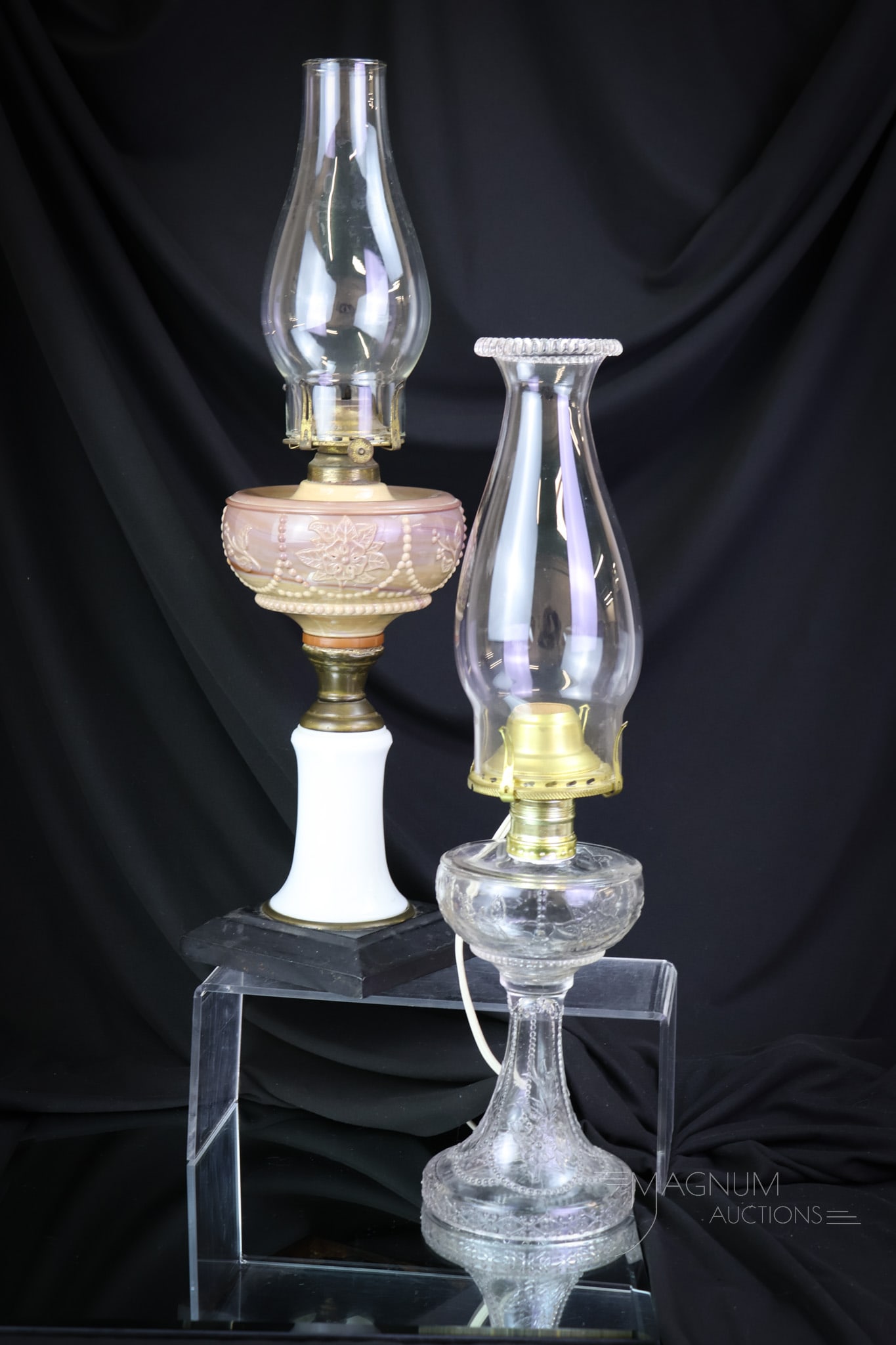 2 pc Lot McKee Wild Rose & Bowknot Victorian Oil Lamps: Here's a pair of oil lamps by McKee that'll be sure to draw some attention. The first is a small, clear example. The larger one has a chocolate glass font with a milk glass stem and metal foot. The ta