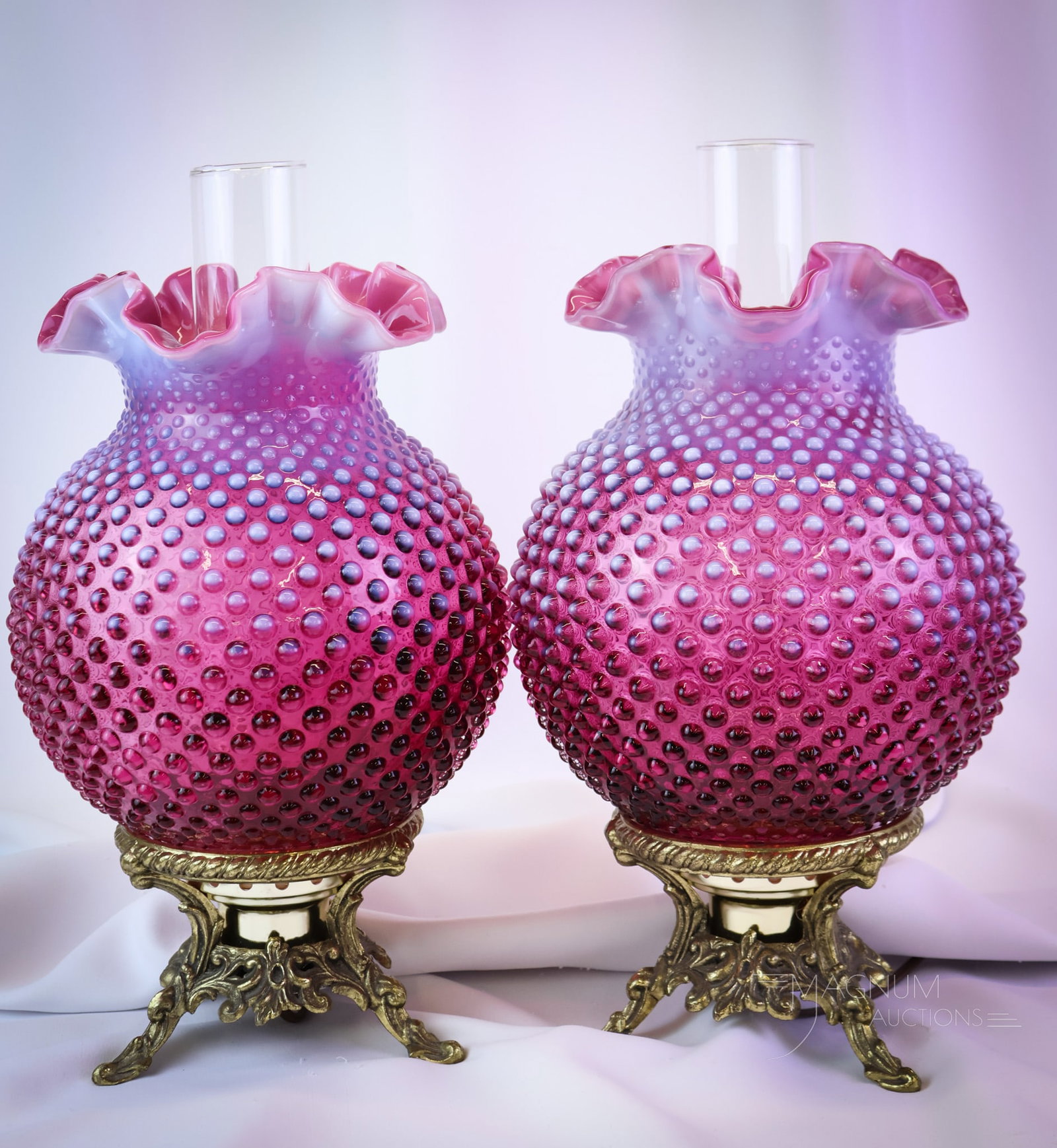 2 pc Lot Fenton Cranberry Opalescent Art Glass Stumpy Lamps: A beautiful offering of two Fenton art glass cranberry opalescent Hobnail pattern lamps. Each has a nice brass base. Both measure 13 1/2" tall and 8" wide. SHIPPING NOTICE: If you choose not to utiliz