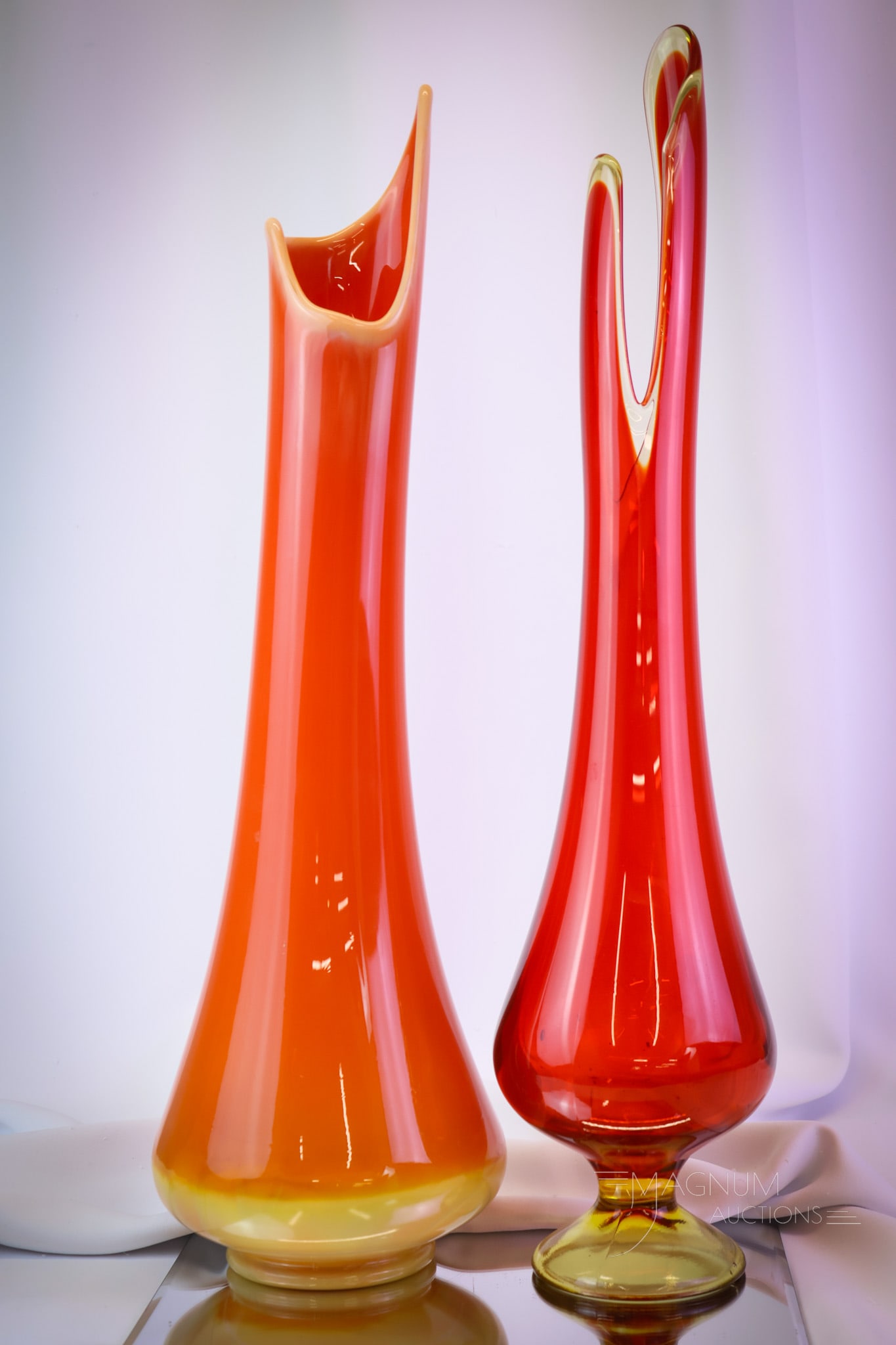 2 pc Lot L.E. Smith Swung Art Glass Vases: Two brilliant colored swung vases for the Swinger in your life! Both were made by L.E. Smith. The first is a smoothie in a Bittersweet color. The second is a flame Simplicity footed example. The talle