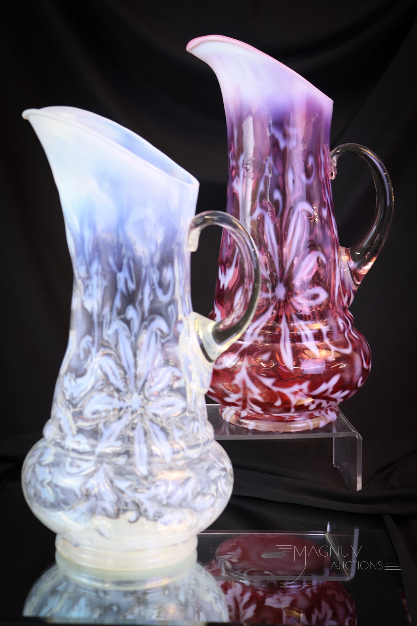 2 pc Lot Northwood Poinsettia Opalescent Victorian Glass Water Pitchers: Two lovely examples of Victorian glass water pitchers in the Poinsettia pattern. One in crystal opal and one in cranberry opal. The unfortunate thing is that the cranberry example is as-is with a crac