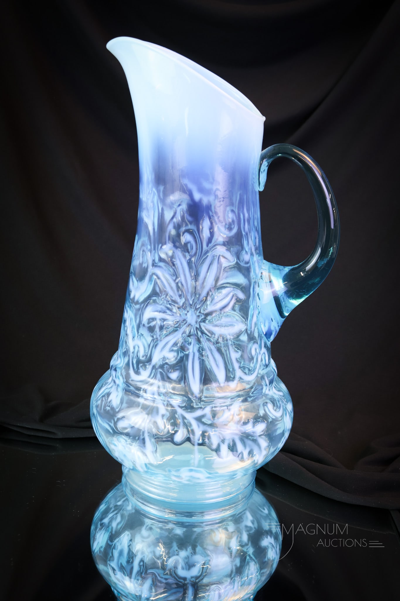 Victorian Northwood Blue Opalescent Poinsettia Water Pitcher: A striking and beautfiul example of a Northwood classic water pitcher. This lovely find will grace any collection. The pitcher measures 13 1/4" tall. Provenance: This item is from the private collecti