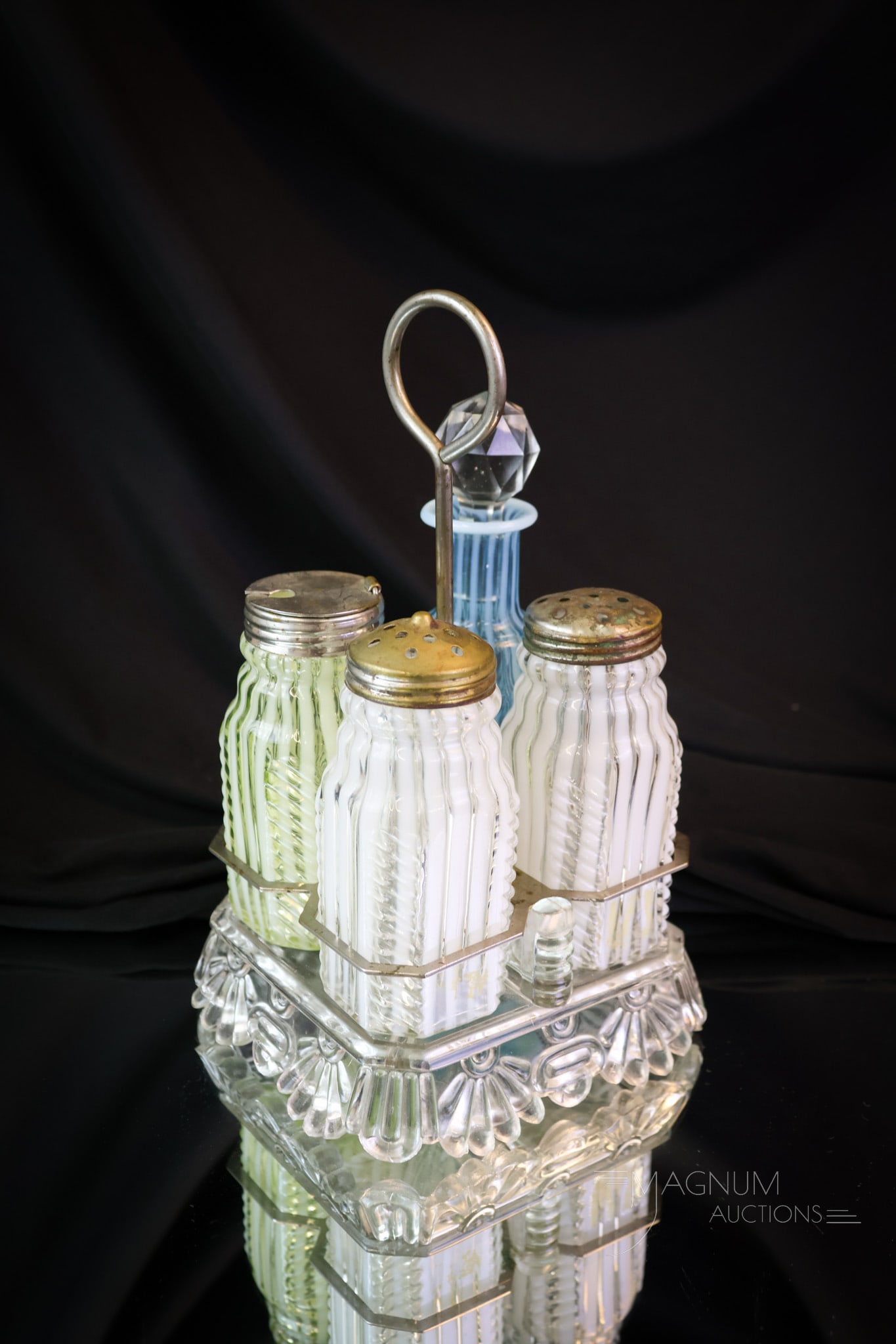 Victorian Opalescent Urnaium & More Glass Condiment castor: A beautiful and desirable Victorian opalescent glass condiment castor. This set includesblue , vaseline, and crystal opalescent bottles in a clear stand with metal handle. The complete set measures 8
