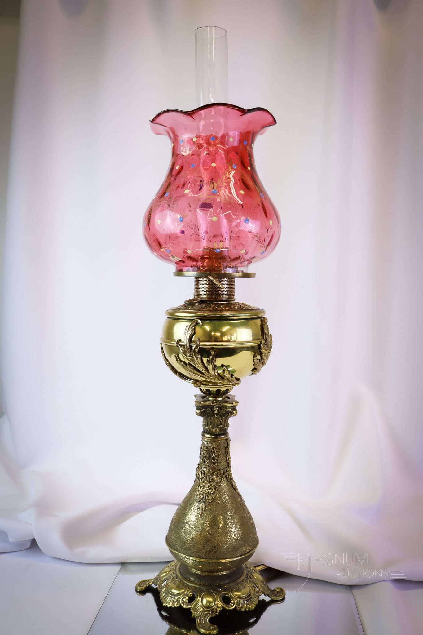 Bradley & Hubbard Victorian Cranberry Enameled Glass Banquet Oil Lamp: A nice find in a Bradley & Hubbard Victorian oil lamp complete with a cranberry enameled glass shade. The base is quite ornate and has been electrified. The shade is a rich cranberry glass and is enam