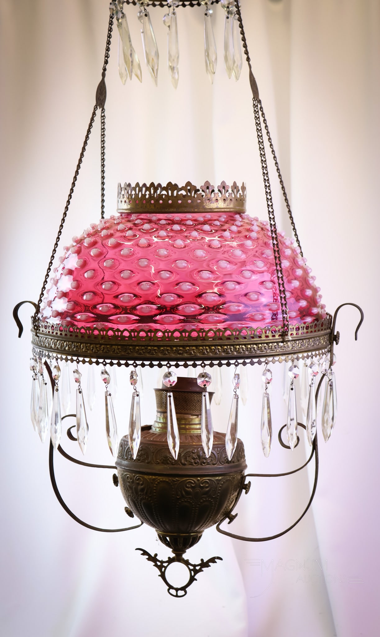 Victorian Bradley & Hubbard Cranberry Opalescent Hobnail Hanging Parlor Oil Lamp: A quintessentially Victorian hanging parlor oil lamp. This lamp is signed Bradley & Hubbard. The shade is by Hobbs and in cranberry opalescent glass in the Hobnail pattern. The Lamp retains the origin
