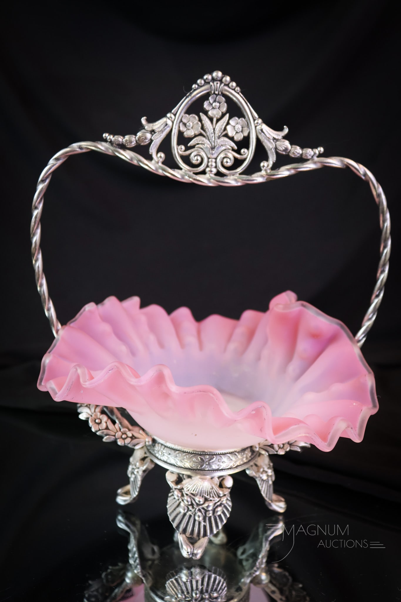 Tufts Silverplate Victorian Miniature Heart Shaped Brides' Basket: A charming and diminutive find in Victorian glass and silverplate. This is a miniature bride's basket. It is complete with a heart-shaped pink satin glass bowl. The holder is marked Tufts. The base of