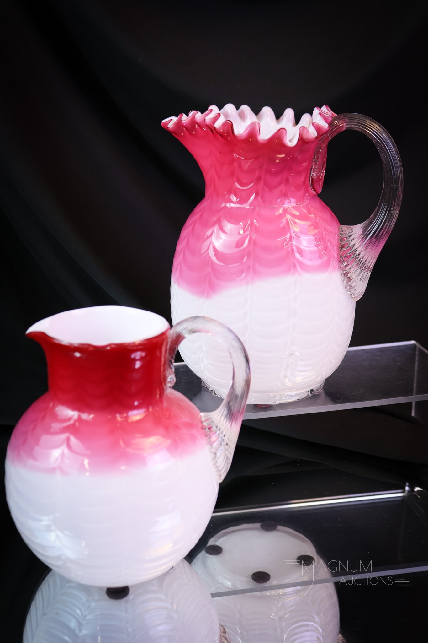 2 pc Lot Phoenix Pink Cased Drape Victorian Glass Pitchers: Two unique finds in the same pattern. This lot offers two pitchers in cased pink drape pattern. These are attributed to Phoenix. Each is a beauty that is sure to be collection-enhancing. The tallest m