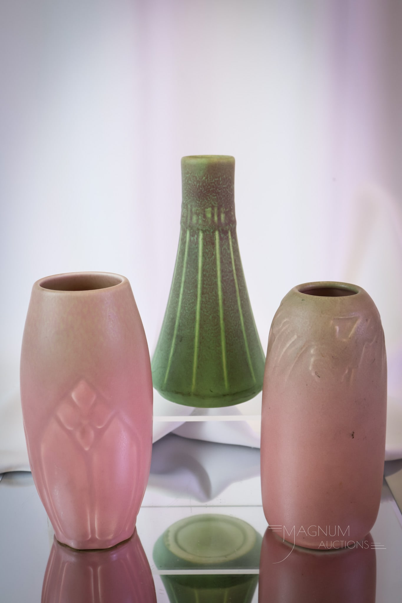 3 pc Lot Rookwood Arts & Crafts Matte Glaze Pottery: Three decorative finds in Arts & Crafts period Rookwood pottery. The first is a matte green with maroon coloring at the top. The second is a Mulberry colored piece with embossed design at the top. The