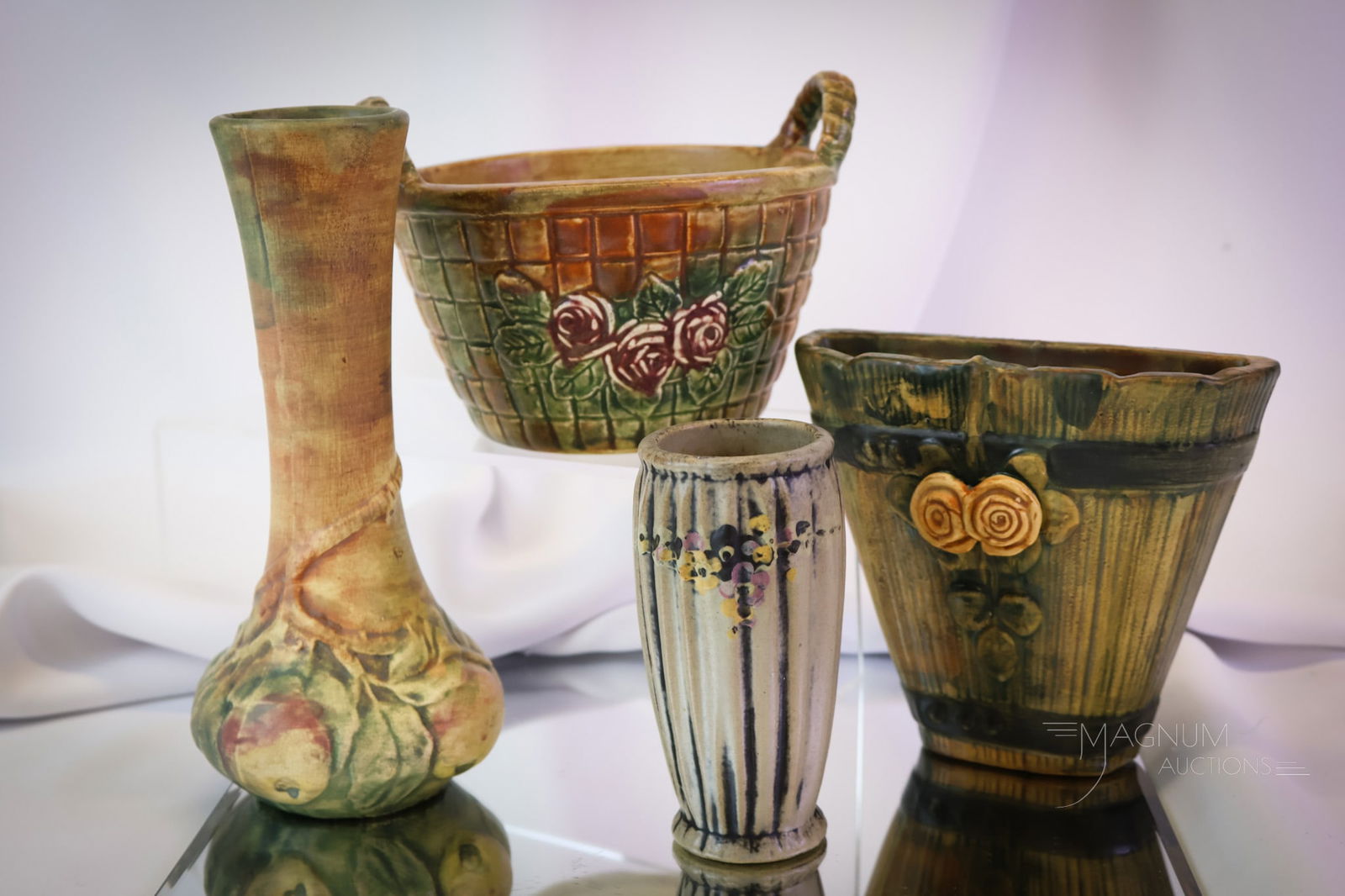 4 pc Weller Woodcraft Baldin Apple & More Art Pottery: Four unique finds in Weller art pottery. This lot includes examples in Woodcraft Balsin and more. There is a wall pocket. A basket. An apple vase. Lastly, there is a decorated vase. The tallest measur