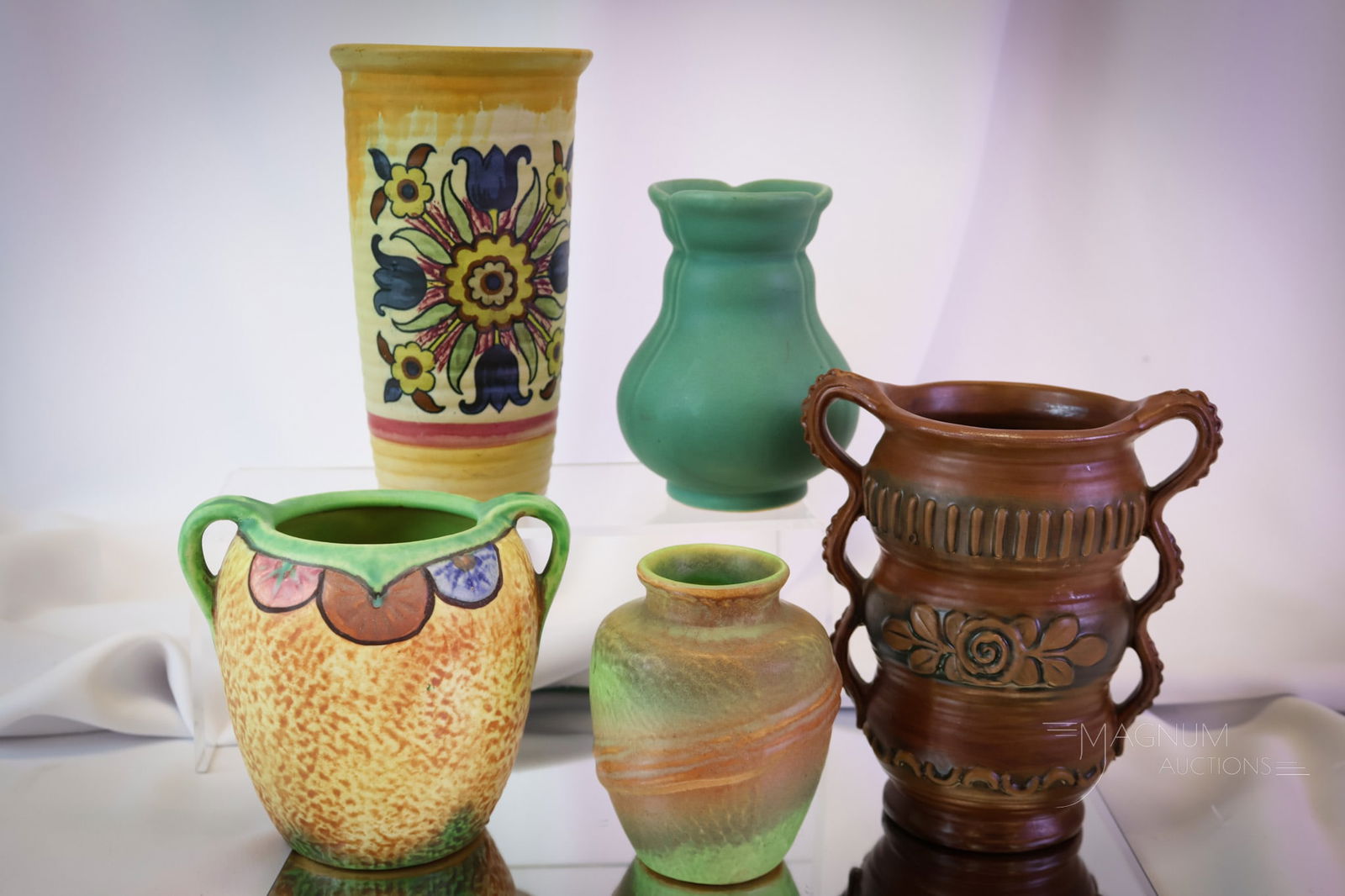 5 pc Lot Weller Art Pottery Stylized Vases: A more than generous offering of Weller stylized vases. There are two handled vases. One matte example. One turquoise. One decorated. Lastly, a green and brown vase. The tallest measures 7". SHIPPING