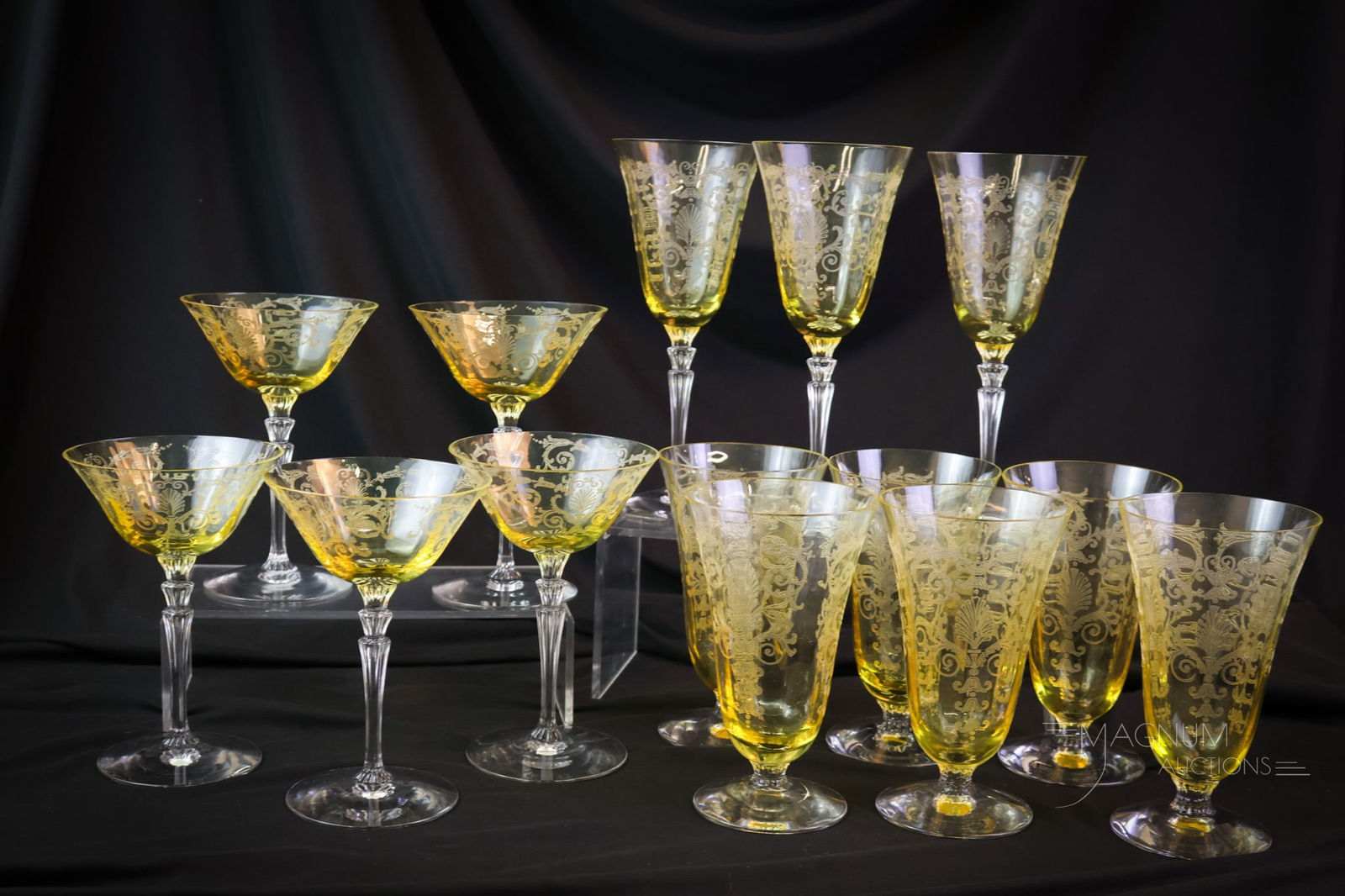 14 pc Fostoria Topaz Versailles Etch Glass Stemware: Fourteen delightful finds in Fostoria Topaz with "Versailles" etch design. This lot includes three water goblets, six footed water tumblers, and five champagnes. The tallest measures 8 1/4". SHIPPING