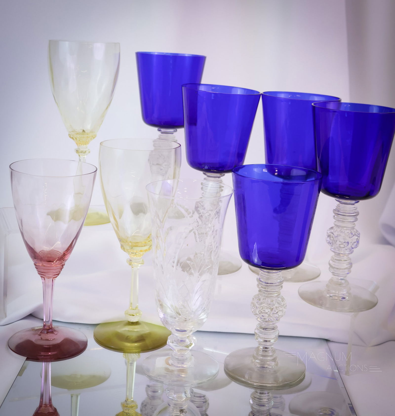 9 pc Lot Heisey Glass Stemware: Nine distinct finds in Heisey glass stemware. This offering includes some real gems, like five Spanish water goblets in cobalt. Two Sahara water goblets. A single Flamingo water goblet and a cut cryst