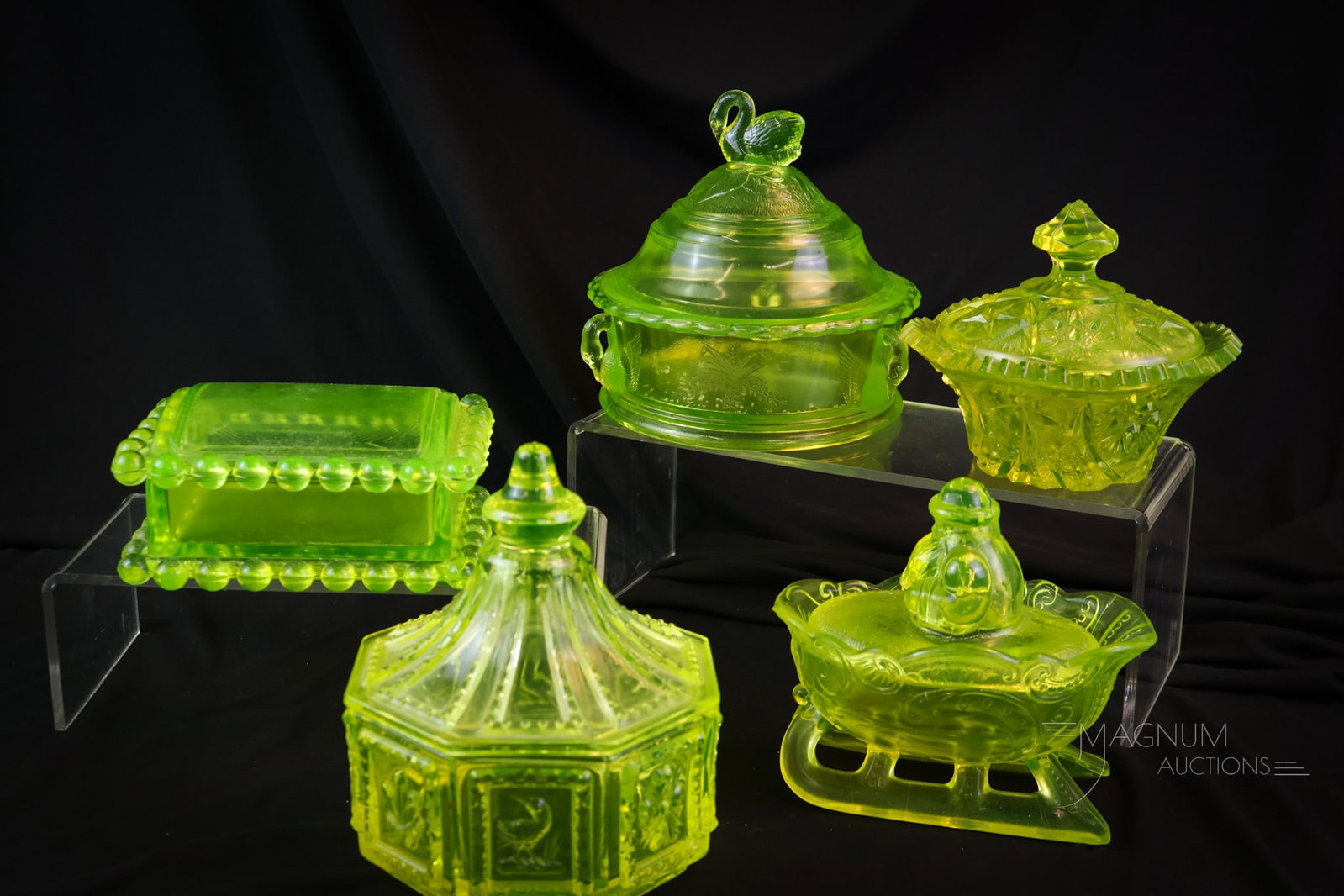 5 pc Lot Vaseline Uranium Glass Covered Boxes: A more than generous offering of five covered dishes in uranium-rich vaseline glass. This lot includes a swan, Santa, Candlewick, and more. Makers such as Westmoreland, Summit, & more. The tallest mea