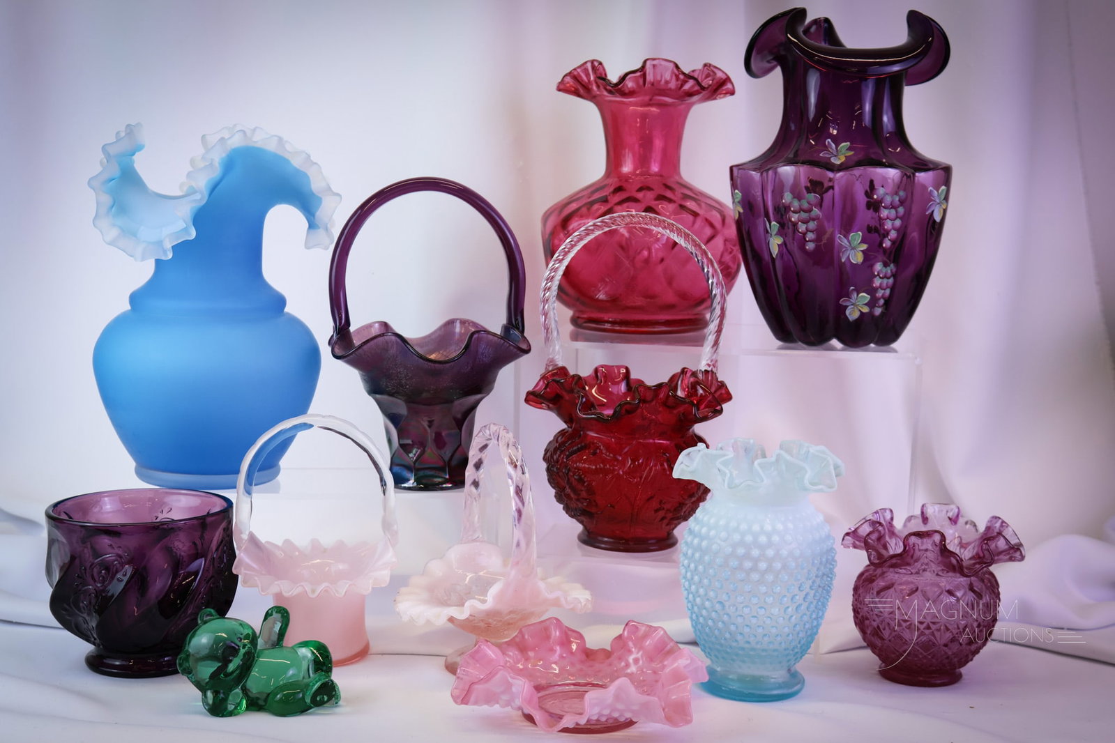 12 pc Lot Fenton Art Glass: Twelve collectible pieces of Fenton Art Glass. This lot includes four baskets, five vases, a candy base, a bear, and a bonbon. The tallest measures 10 1/2". SHIPPING NOTICE: If you choose not to utili