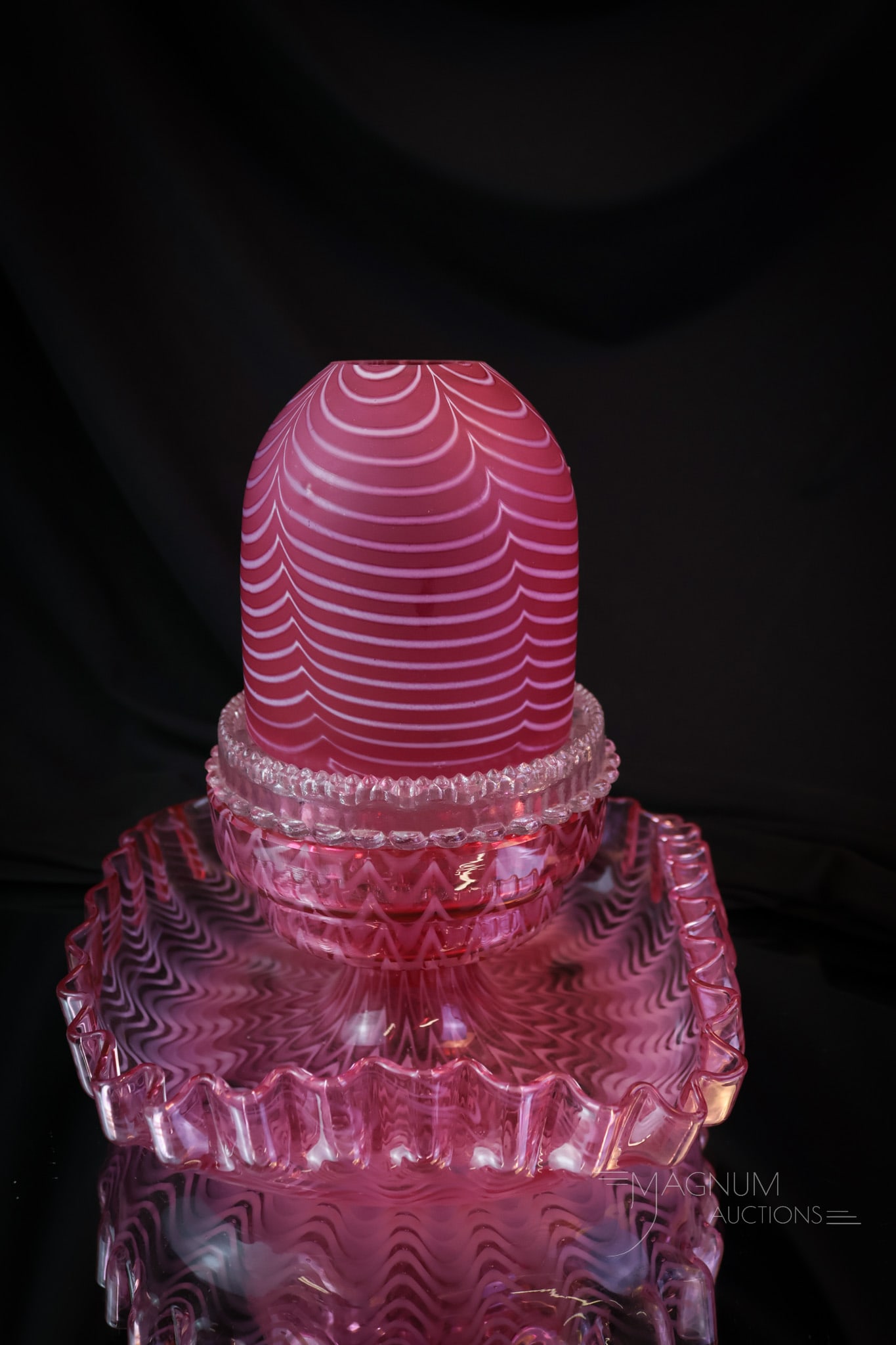 Cranberry Victorian Nailsea Variant Glass Fairy Lamp: A beautiful Victorian cranberry fairy lamp in a Nailsea glass variant. The base of this lamp is glossy, and the shade is satin. Complete, the lamp measures 7 1/2" tall and 7" wide. The interior rim of