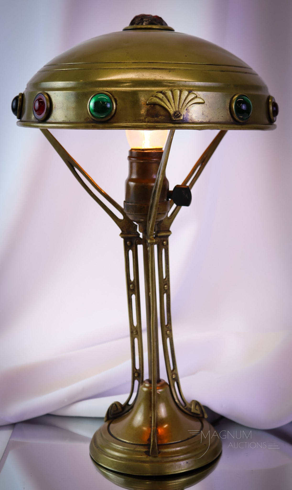 Antique Art Nouveau Sessionist Jeweled Brass lamp: A wonderful find in an antique Art Nouveau period table lamp. This sessionist table lamp features the untouched original patina brass. The shade features cabochon jewels around the rim and an irregula